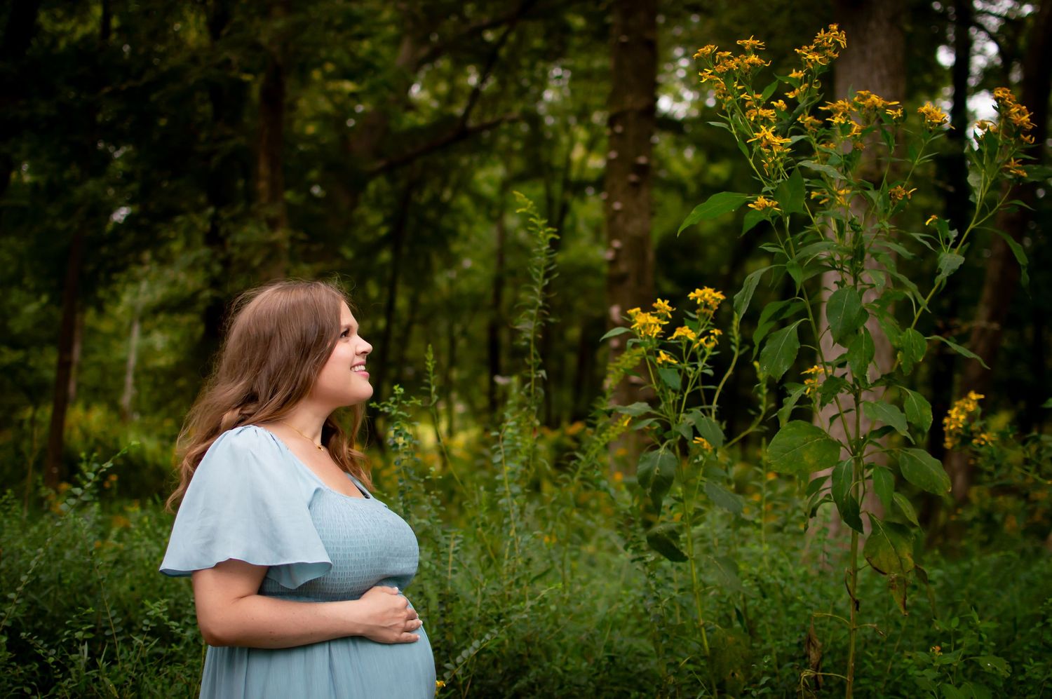 Natural outdoor family photography session among tall wildflowers and greenery.