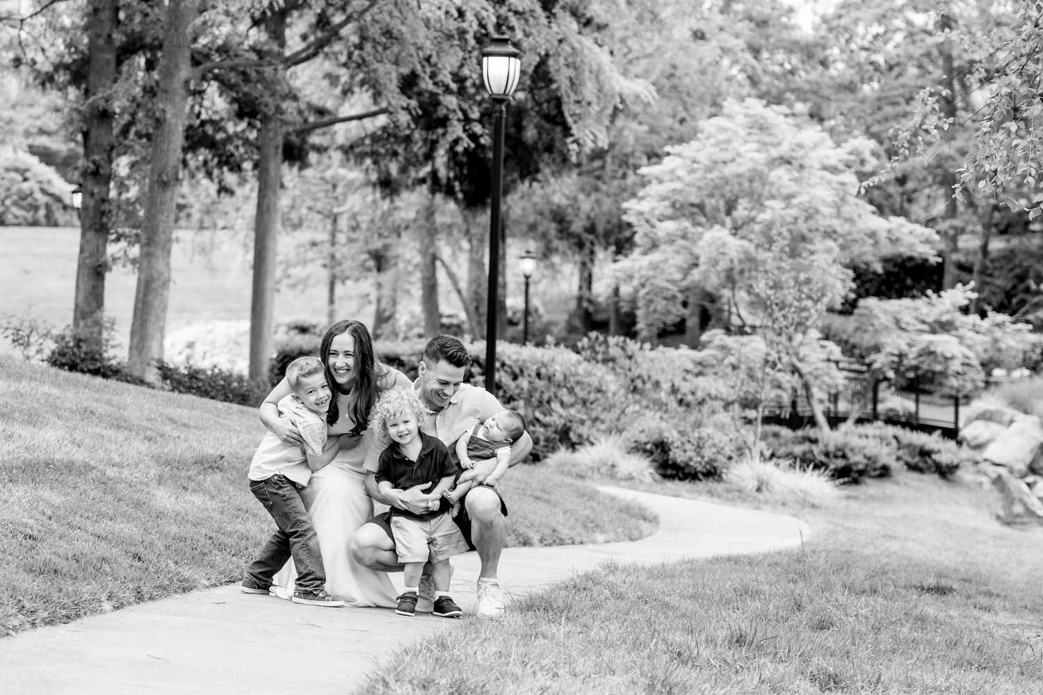 Black and white series captures joyful family moments in a natural outdoor setting.