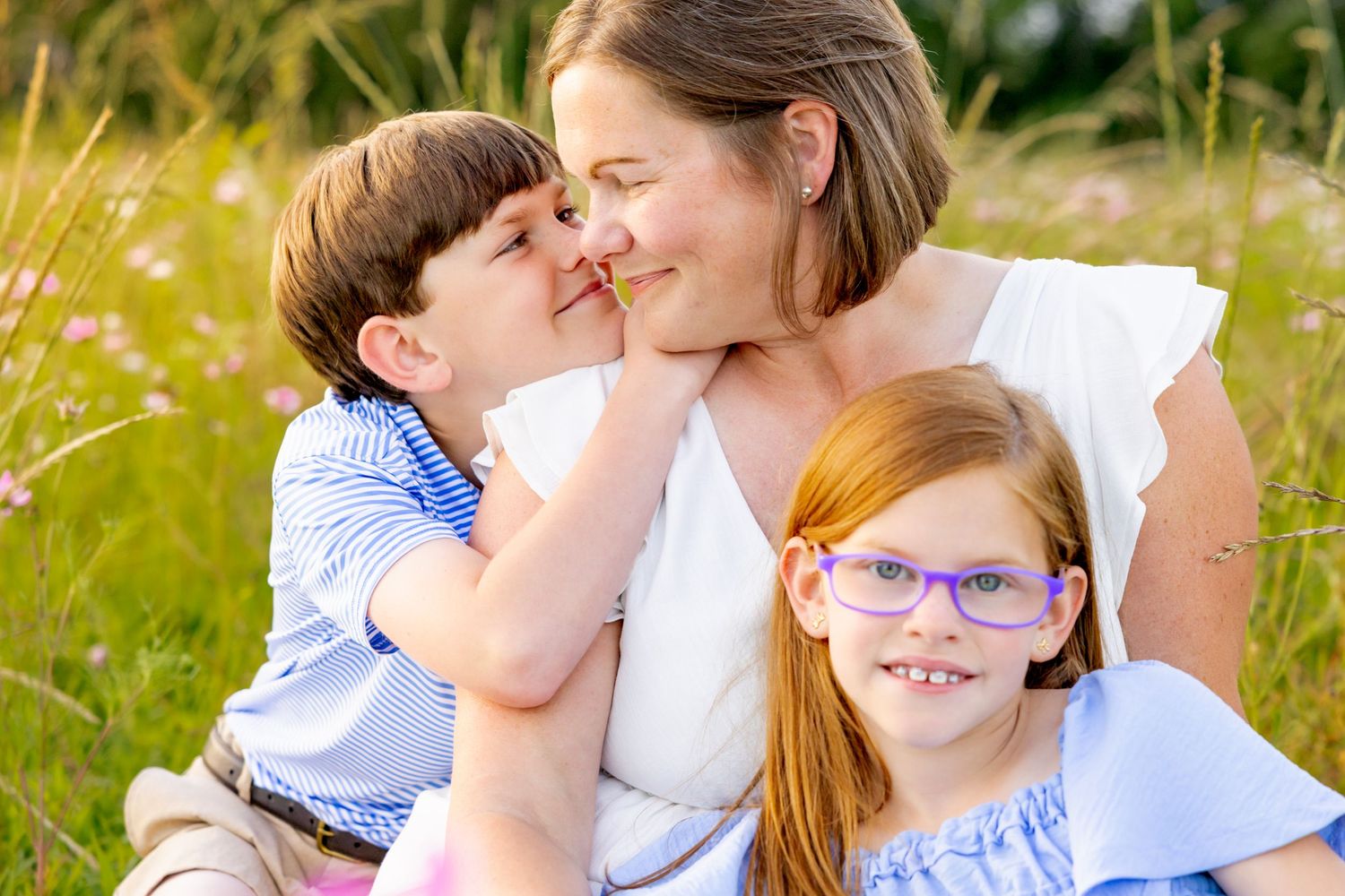 Intimate close-up capturing playful affection and laughter in a sunny meadow setting at Blue Hill Garden in Monroe, NC.