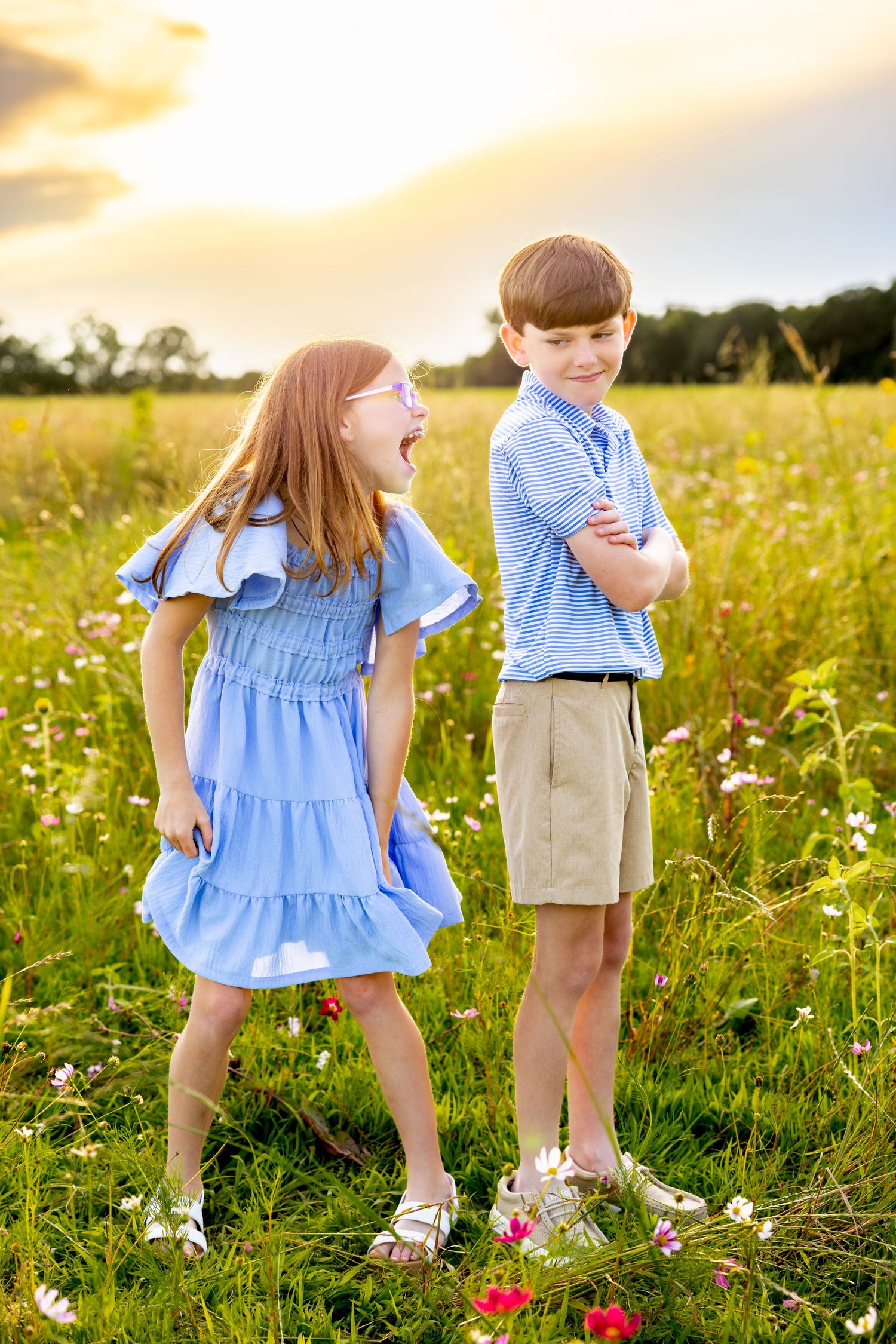 Animated expressions in a wildflower field wearing coordinating blue outfits at sunset at Blue Hill Garden in Monroe, NC.