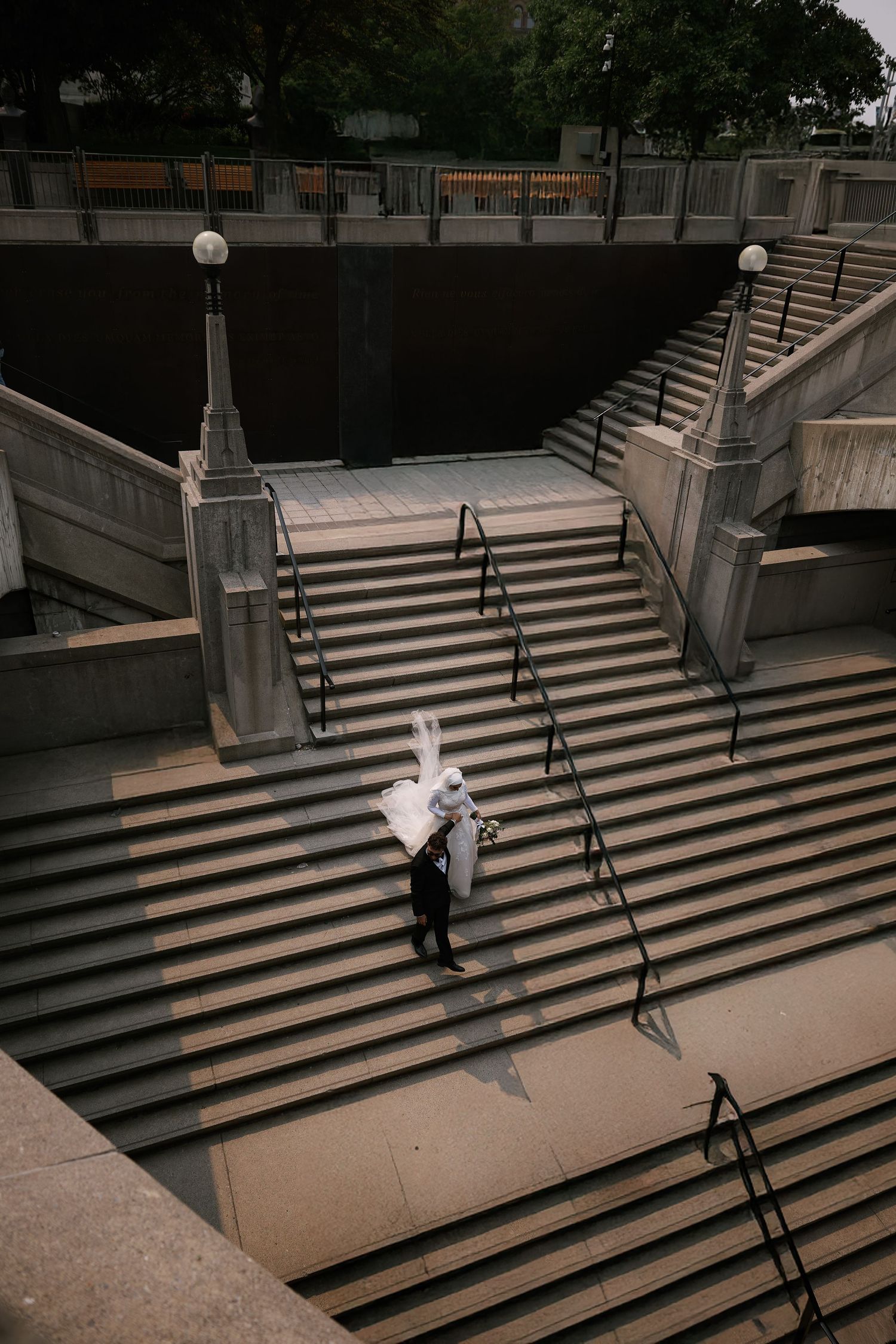 A sequence of four images showing someone walking down concrete steps in an urban setting with metal handrails.