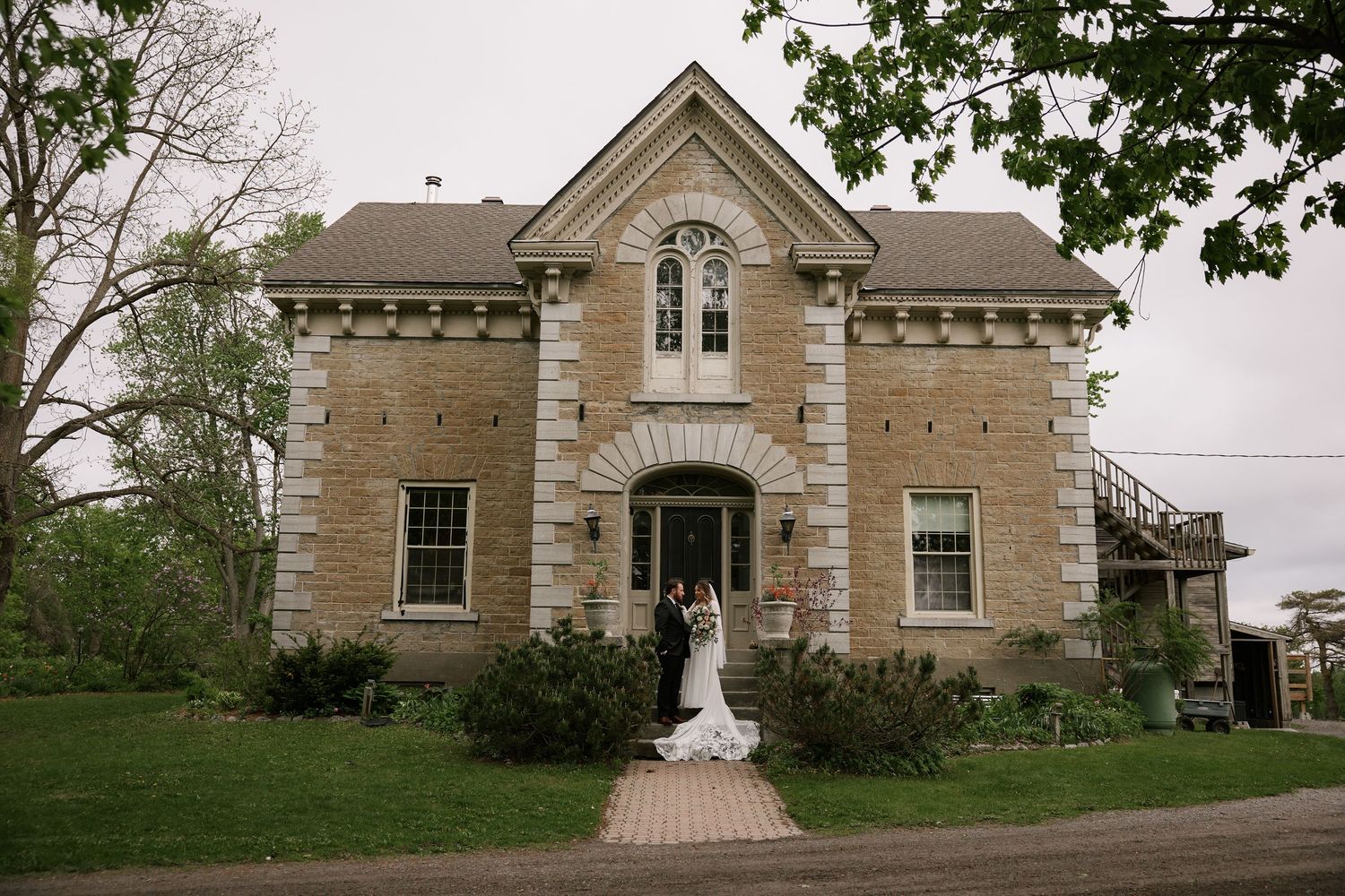 Stone castle-style house with Gothic architectural details and white walkway.