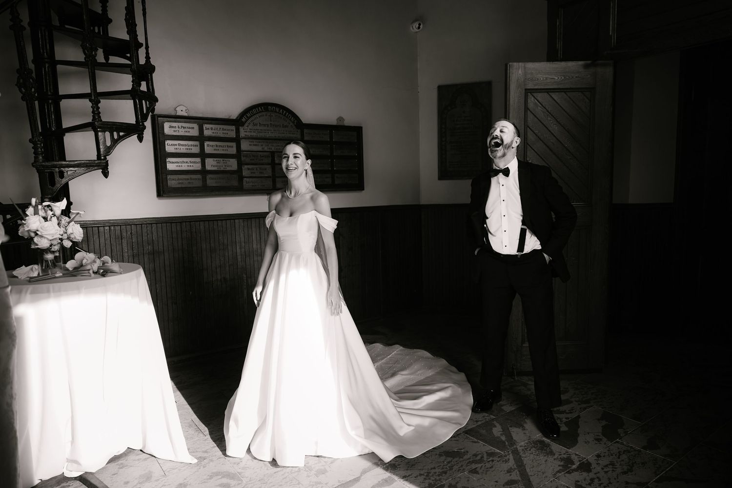 A dramatic black and white wedding photo in an indoor venue.