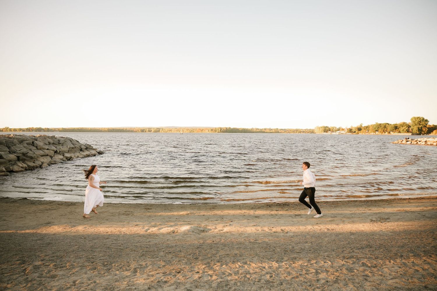 Panoramic beach sequence showing silhouettes of a couple running and embracing at sunset.