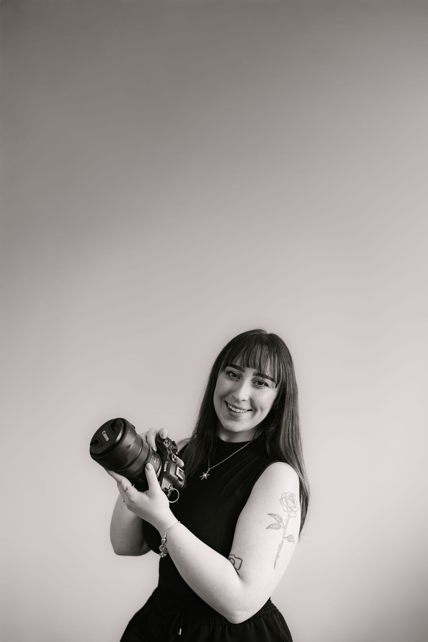 Black and white portrait series showing playful poses with camera equipment.