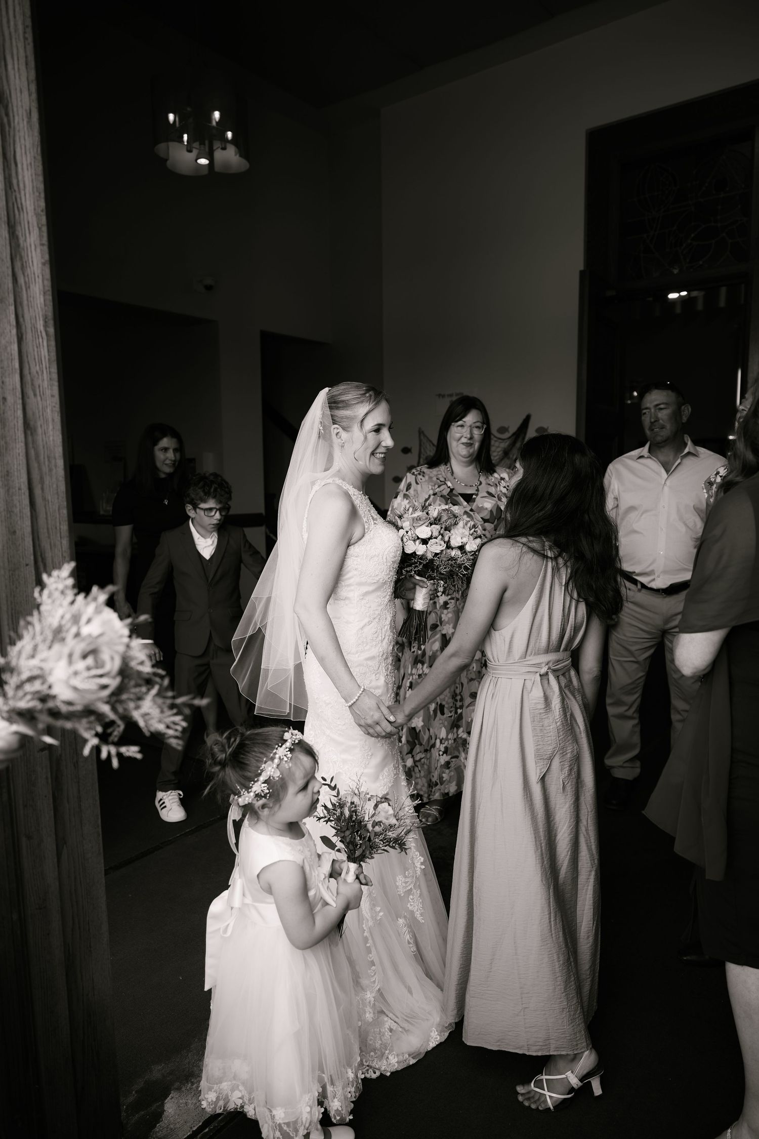 Wedding celebration with bridesmaids dancing in a dark reception hall.