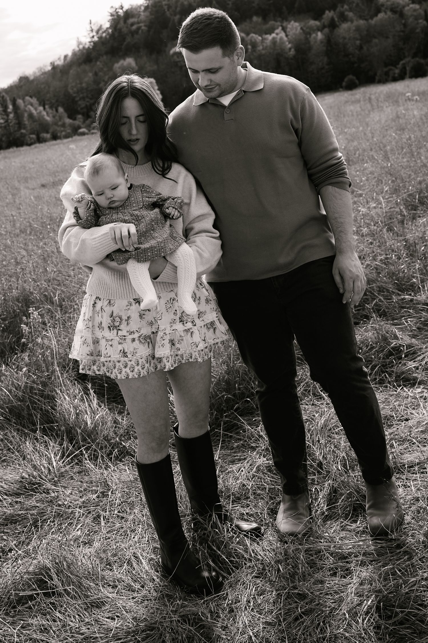 Family walking together through a grassy meadow on an autumn afternoon.