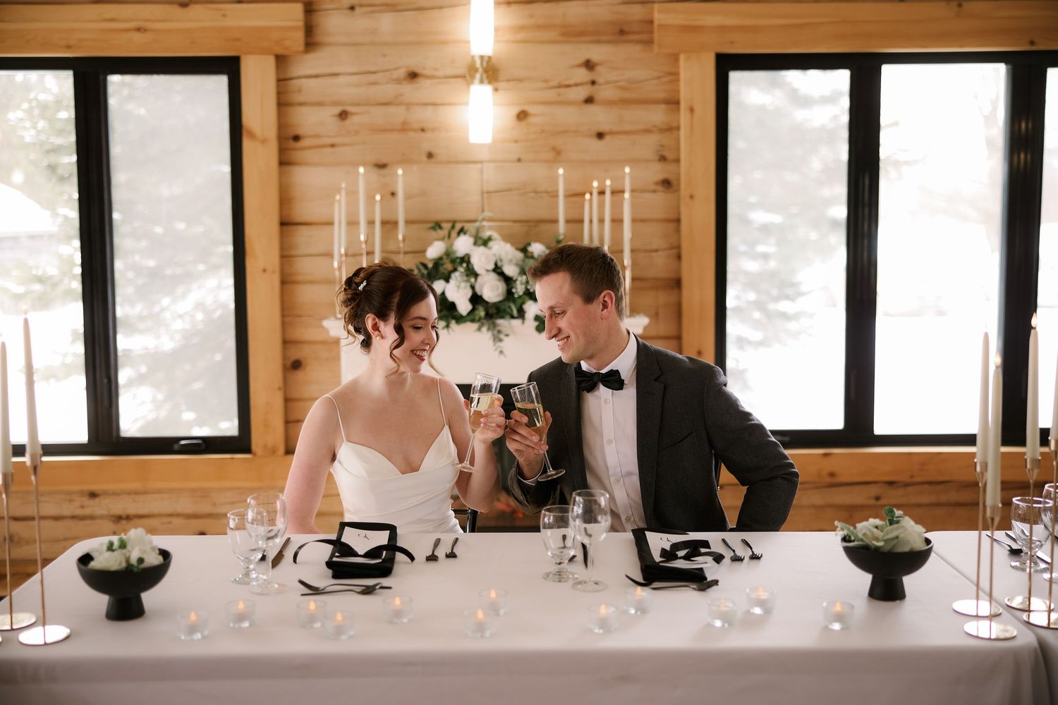 Modern wooden reception venue with elegant table settings and natural lighting.