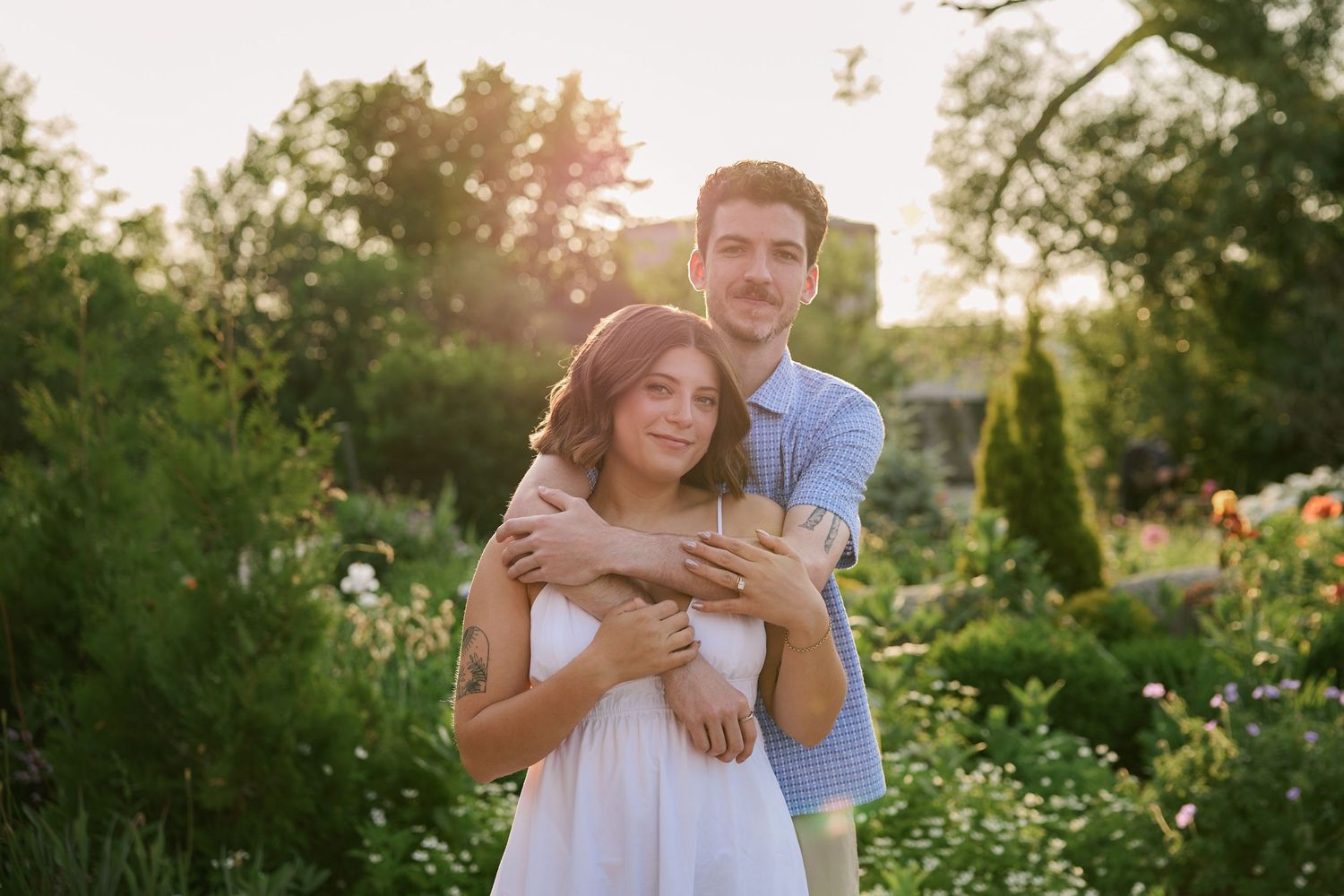 A romantic embrace in a blooming garden during golden hour.