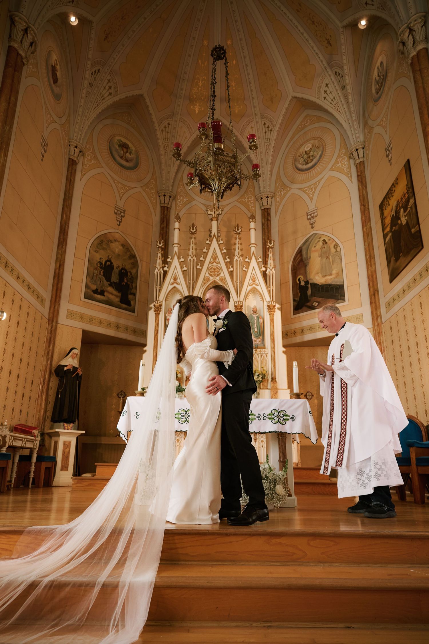 Gothic church wedding ceremony with ornate architecture and flowing veil details.