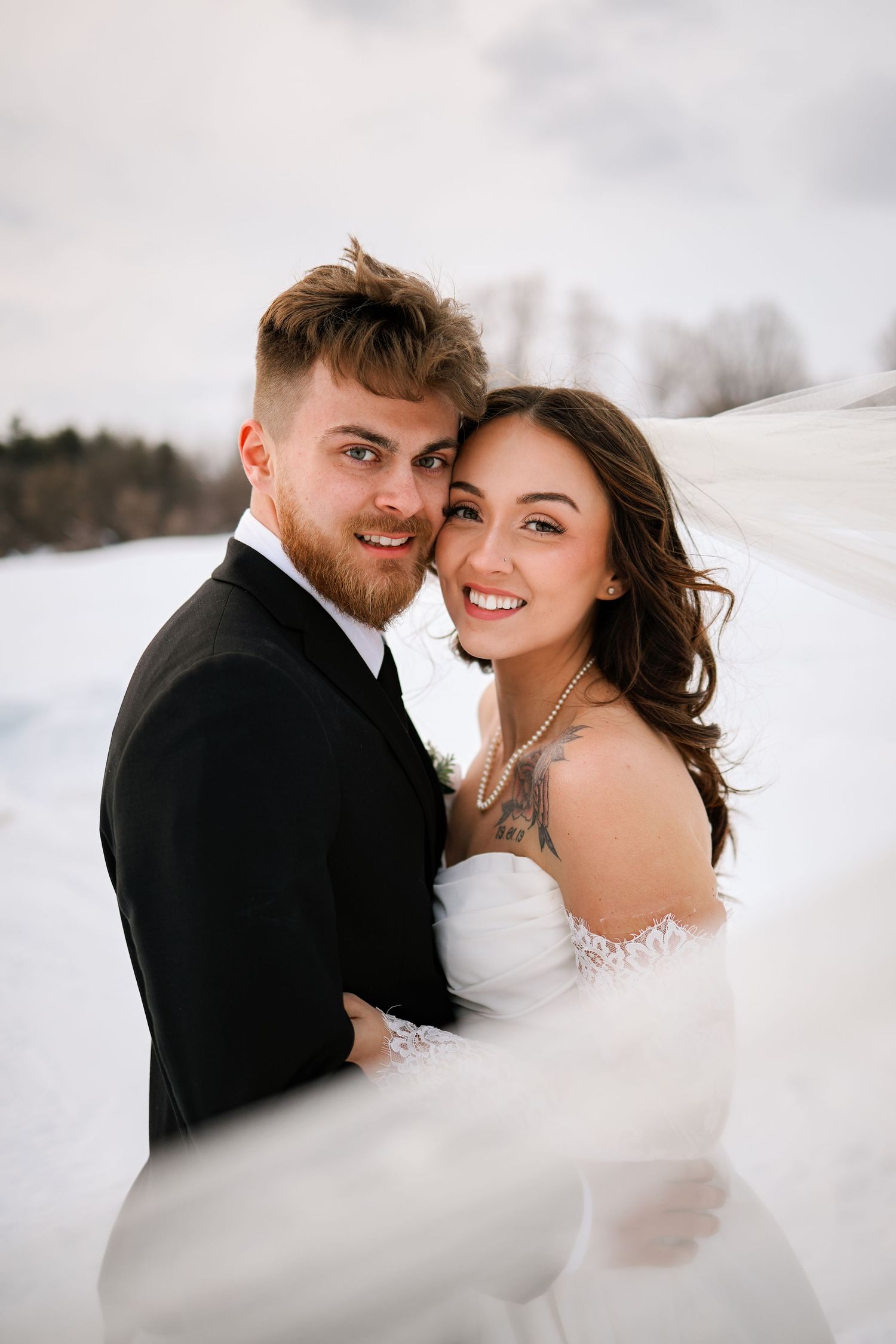 Winter wedding couple sharing intimate moment in snowy setting.