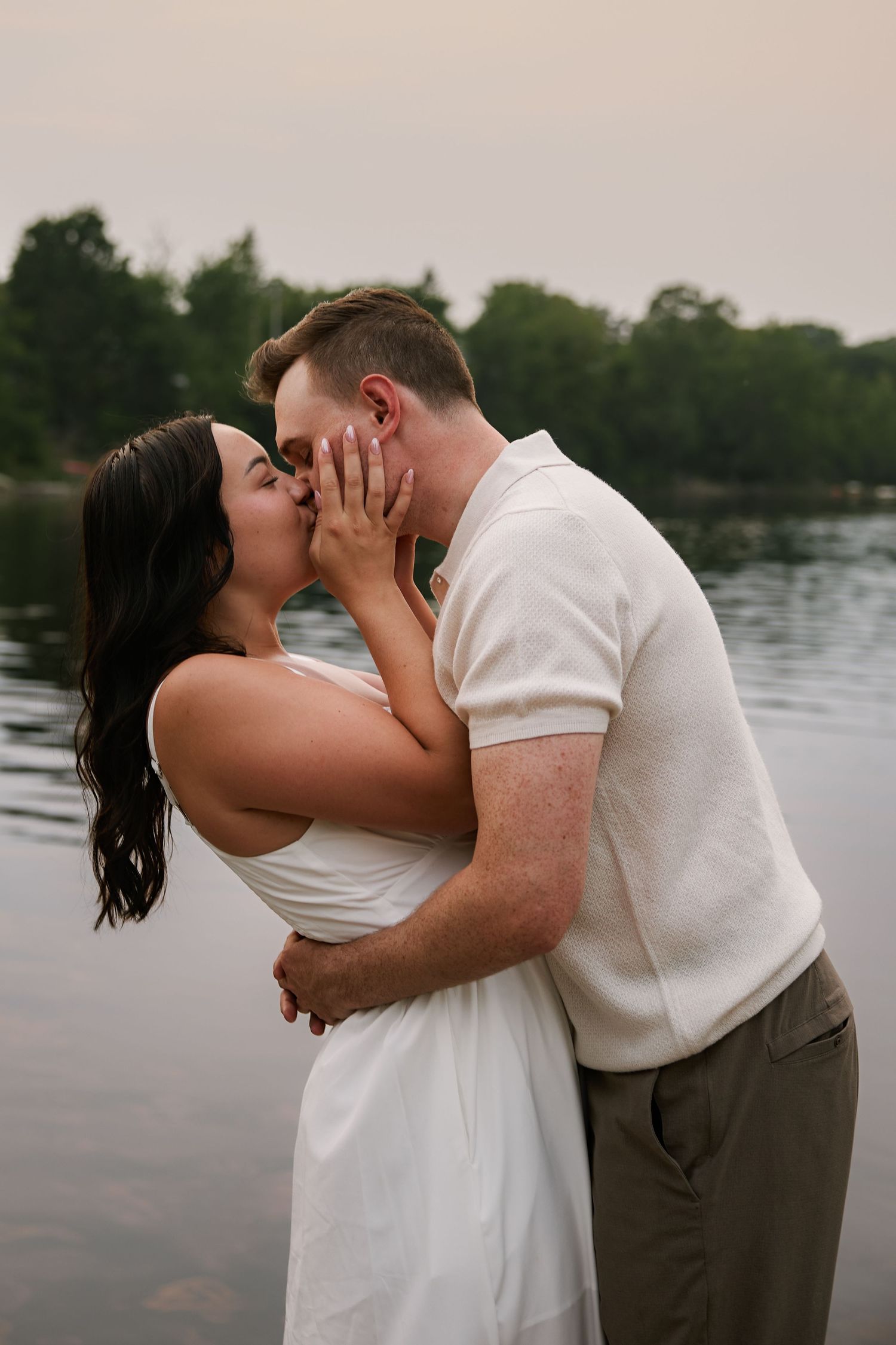 An intimate moment between a couple by the waterfront at dusk.