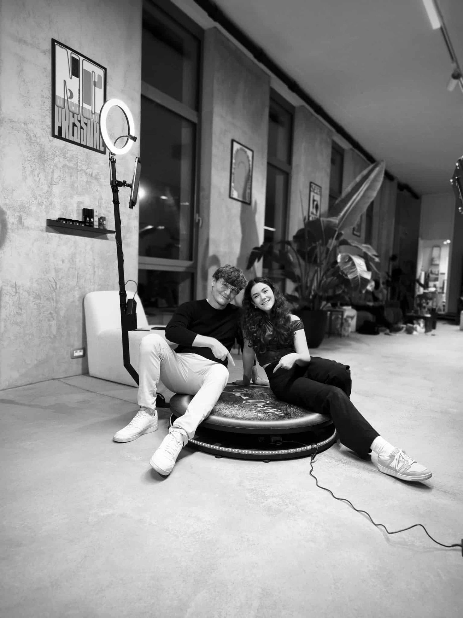 Skupina prijateljev pozira v photoboothu s širokimi nasmehi in zabavnimi propsi, ujeta v živahnem trenutku popolnega event vzdušja.