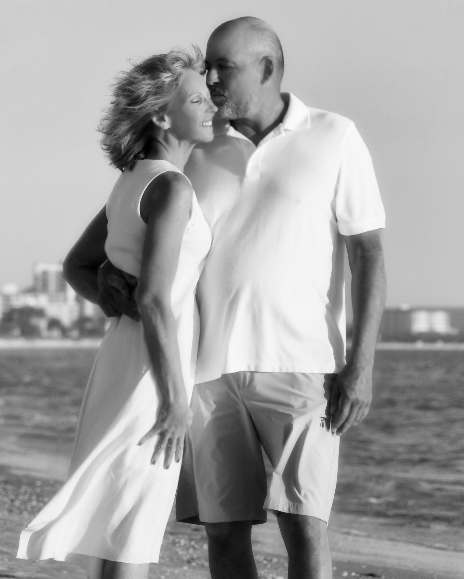 Romantic black and white beach photoshoot series showing tender moments by the ocean.