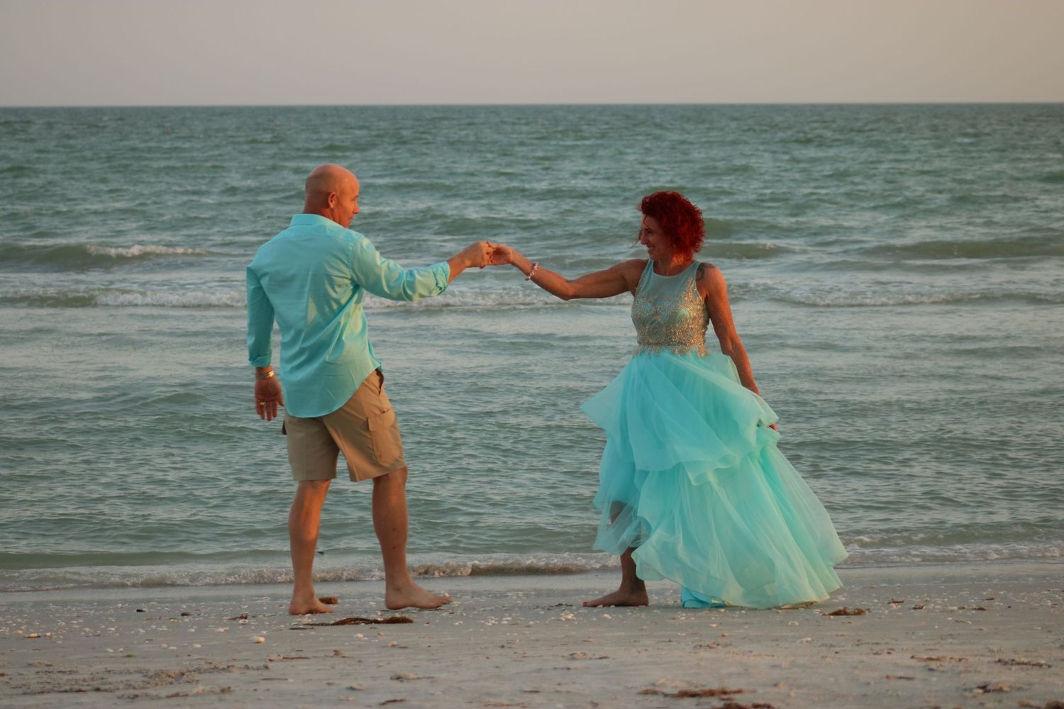 Series of beach portraits with people wearing turquoise outfits walking along the shoreline.