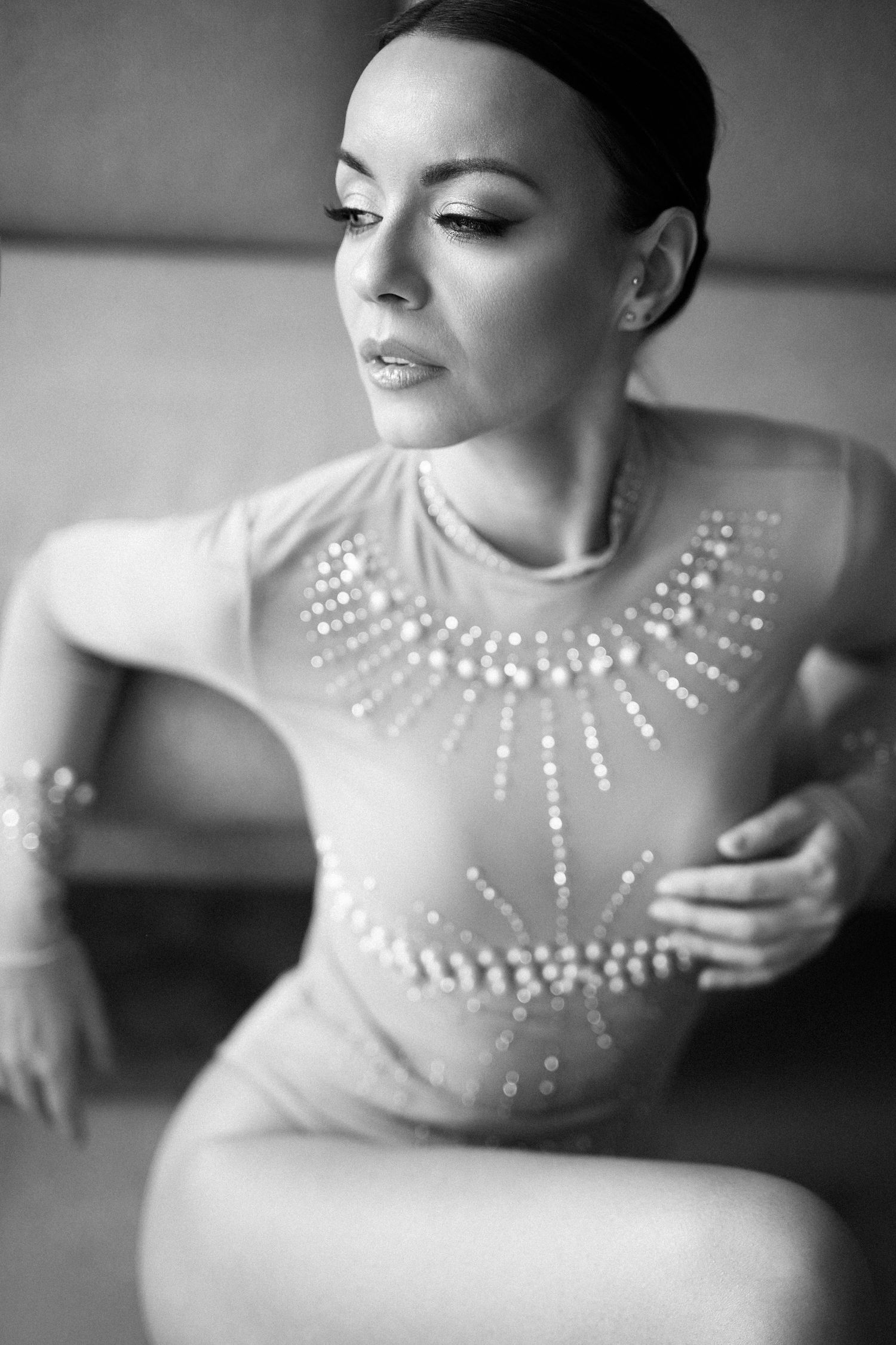 Elegant black and white portrait showing a dancer in a sheer leotard adorned with sparkling crystal embellishments.