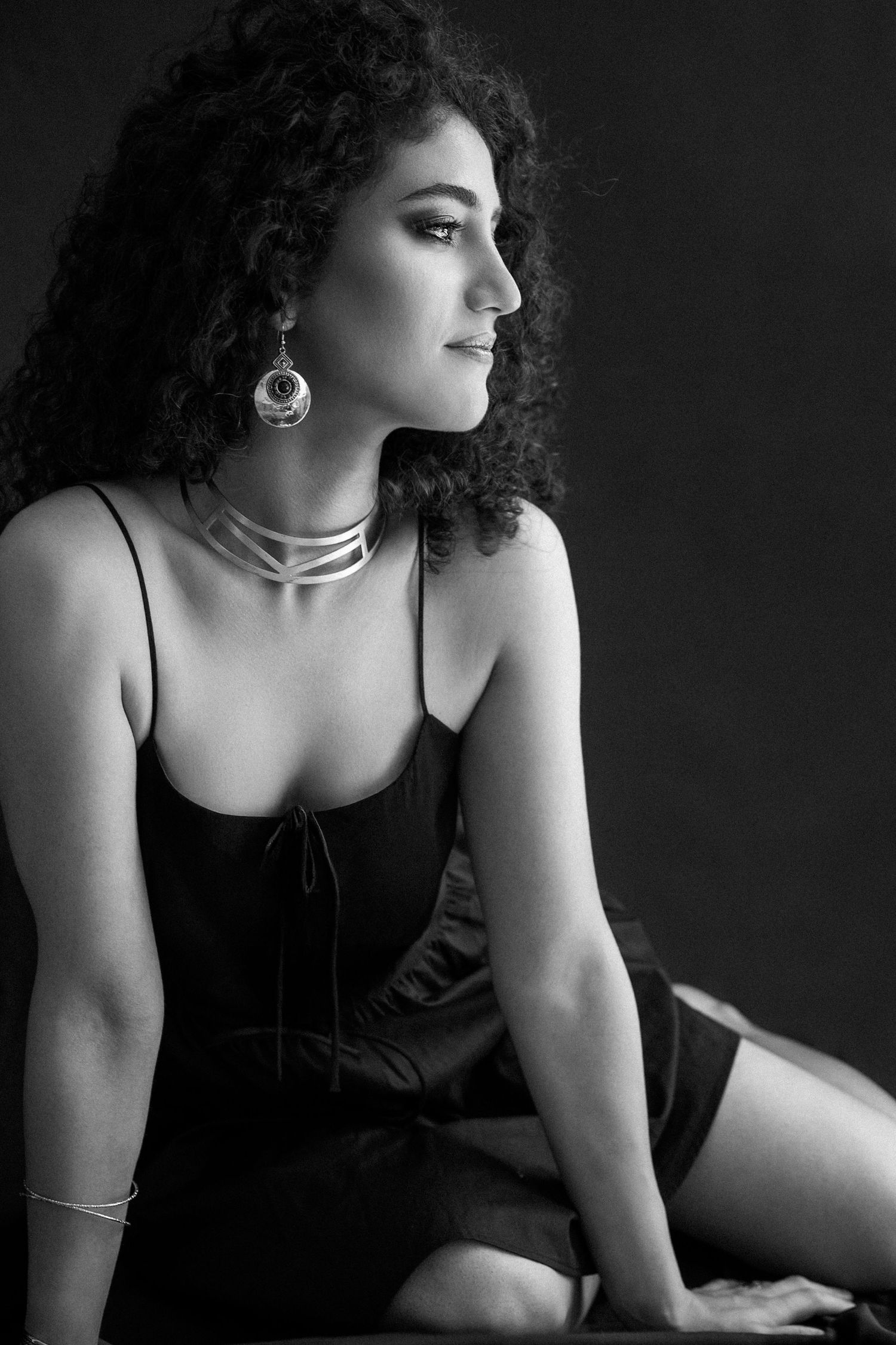 Dramatic black and white boudoir series featuring curly hair and elegant styling.