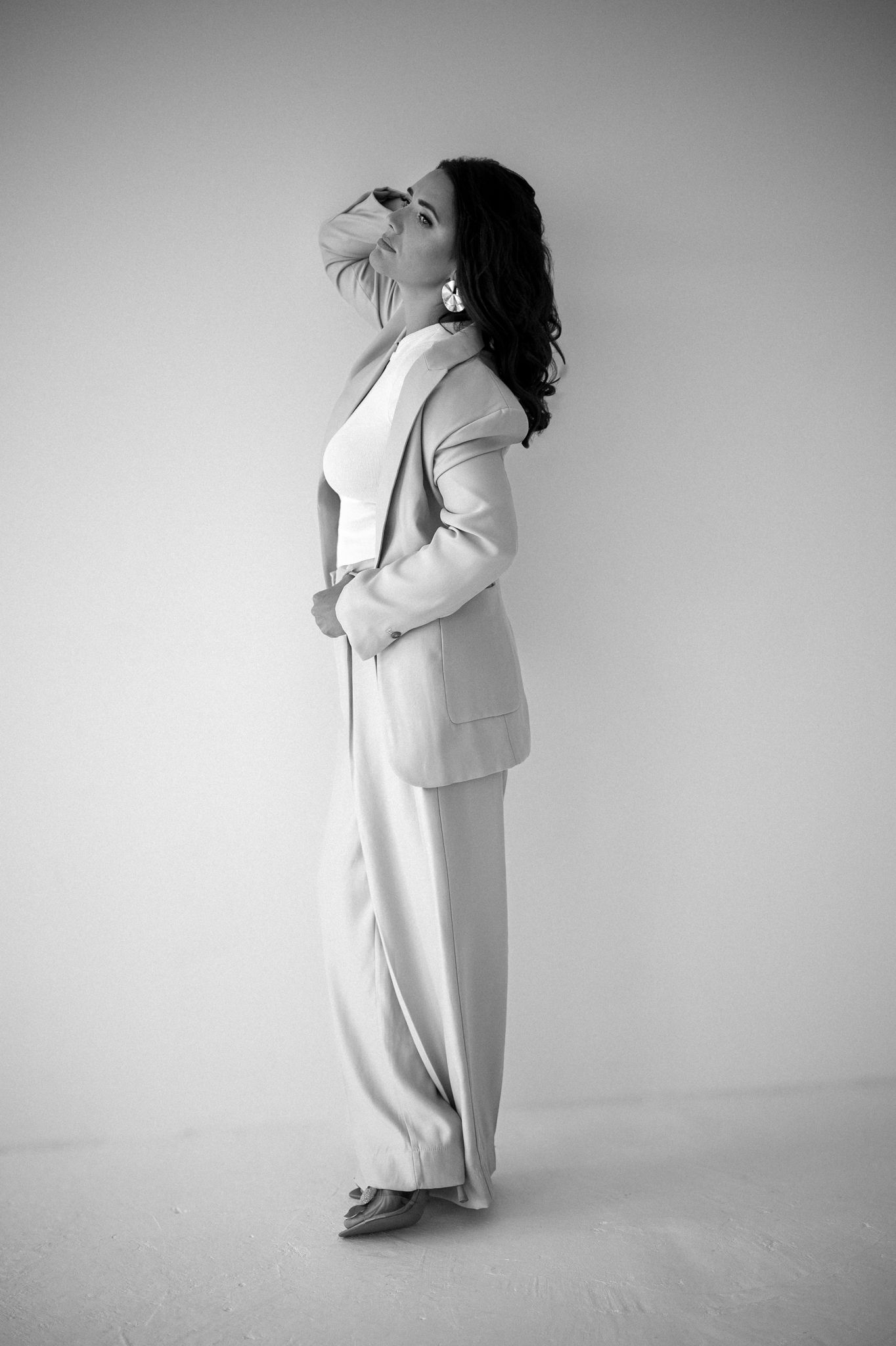 Dramatic monochrome fashion series showing flowing movement in light colored suit.