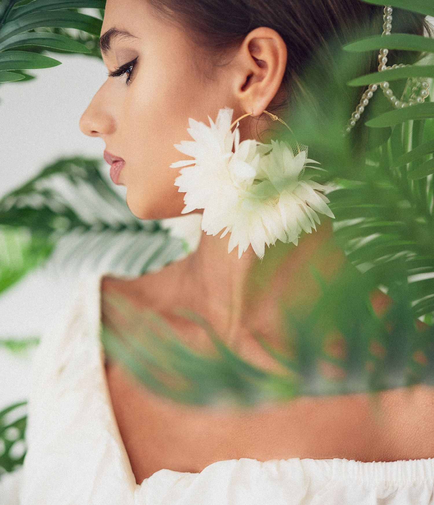 Artistic beauty shot with white flower and tropical leaves creating soft natural elements.