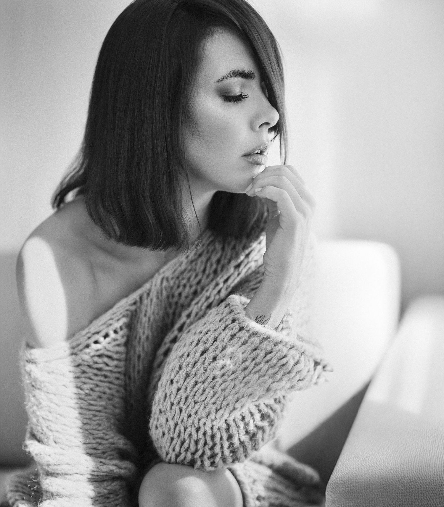 Black and white portrait series showing a woman in a chunky knit scarf looking contemplative in soft lighting.
