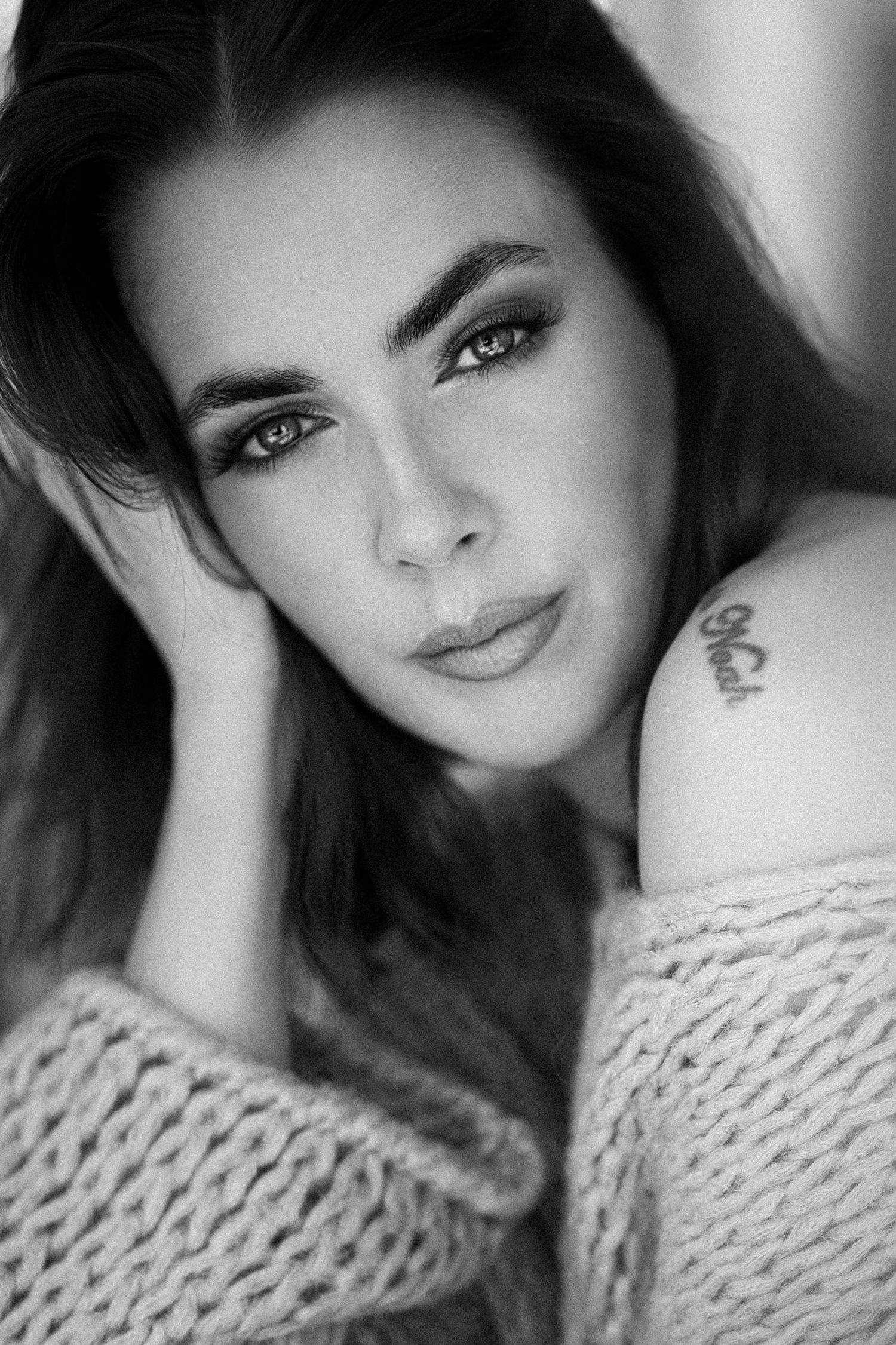 Black and white portrait series showing a person in a knit sweater with dramatic lighting and soft focus effects.