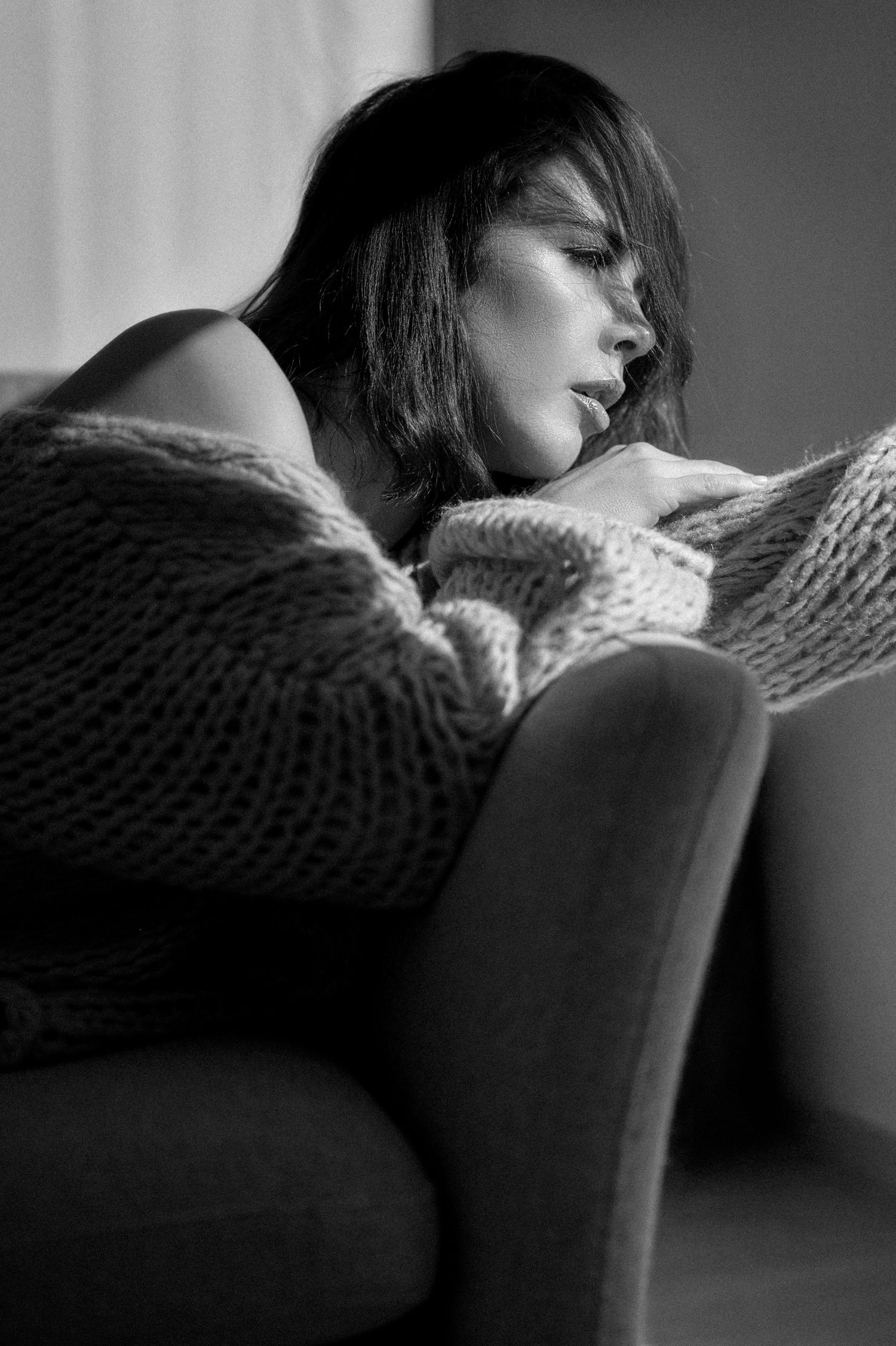 A series of black and white photos showing a person resting their head on the back of a chair in moody lighting.