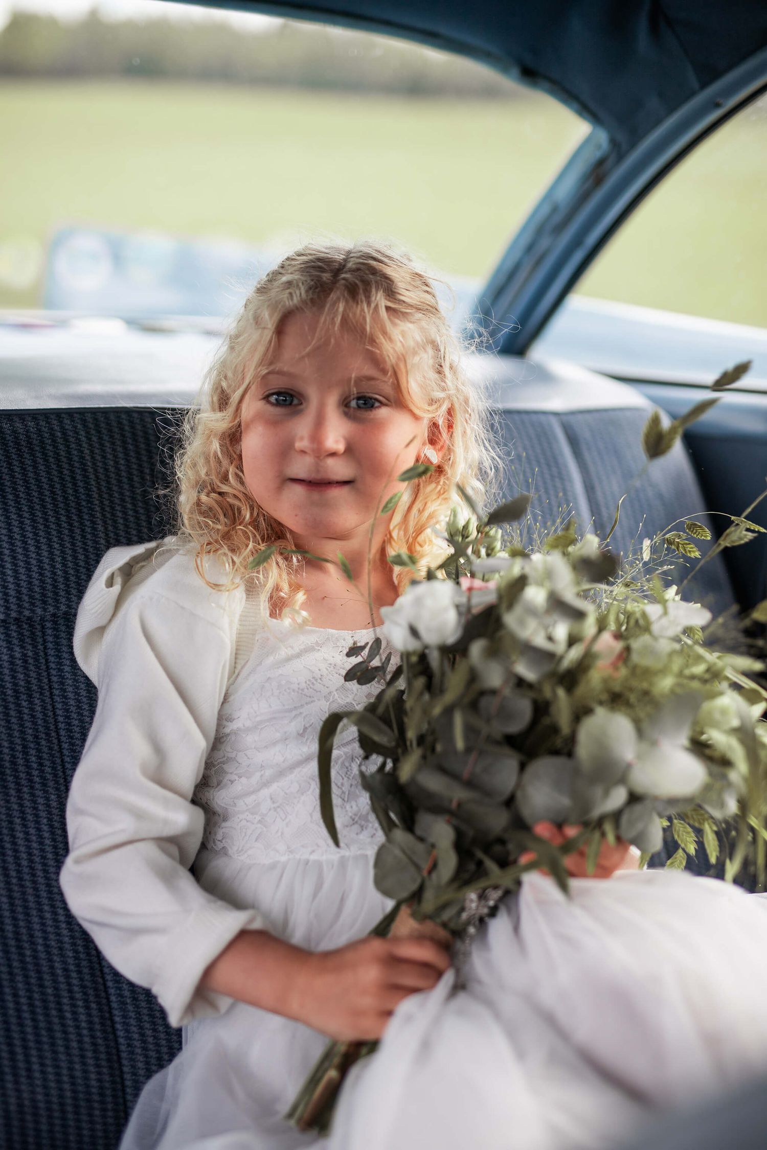 Bröllops i naturen, bland kossor, gräs, bröllopsbågar, bänkar fyllda med gäster, bröllopsfotograf Jennifer serrander