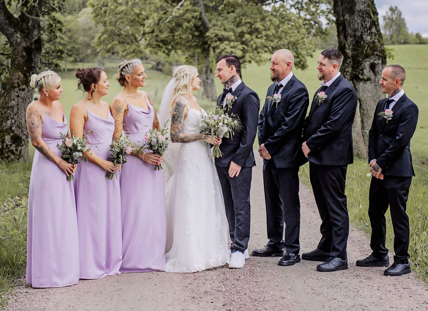 Bröllops i naturen, bland kossor, gräs, bröllopsbågar, bänkar fyllda med gäster, bröllopsfotograf Jennifer serrander