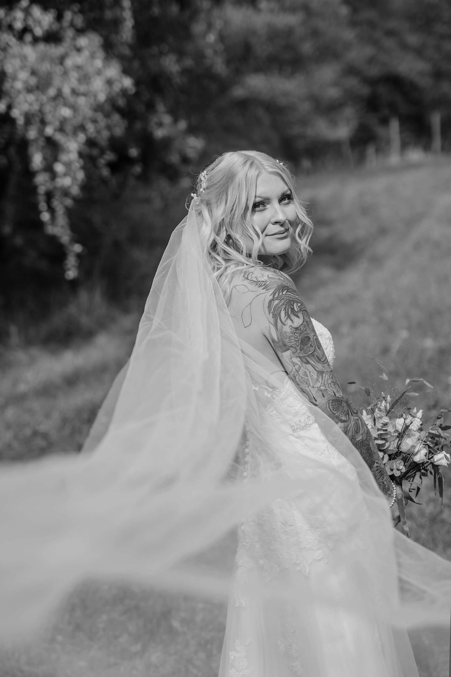 Bröllops i naturen, bland kossor, gräs, bröllopsbågar, bänkar fyllda med gäster, bröllopsfotograf Jennifer serrander