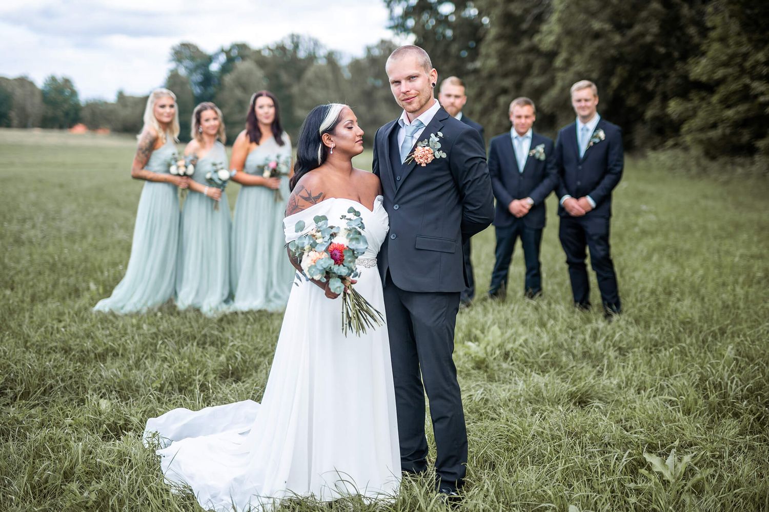 Bröllops i naturen, bland kossor, gräs, bröllopsbågar, bänkar fyllda med gäster, bröllopsfotograf Jennifer serrander
