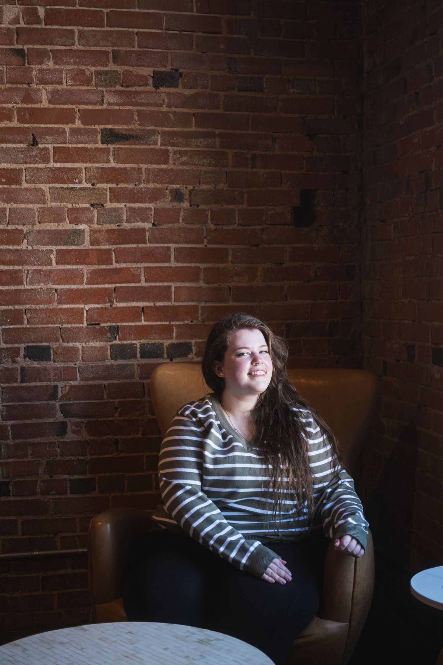 A woman smiling and sitting in a chair in Denton, TX