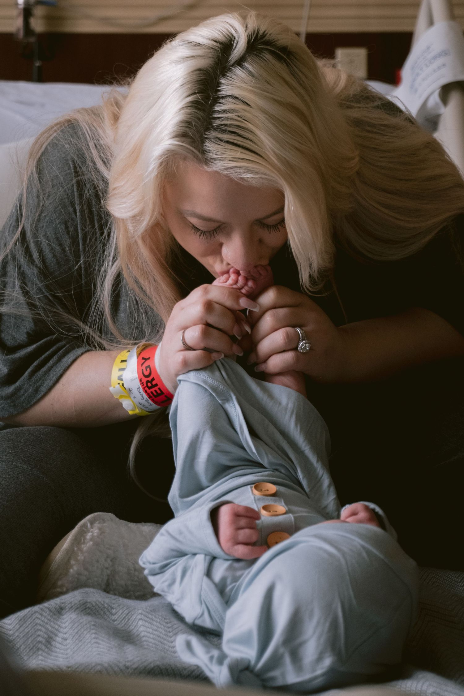 A mom kissing her newborn son's feet in Fort Worth, TX