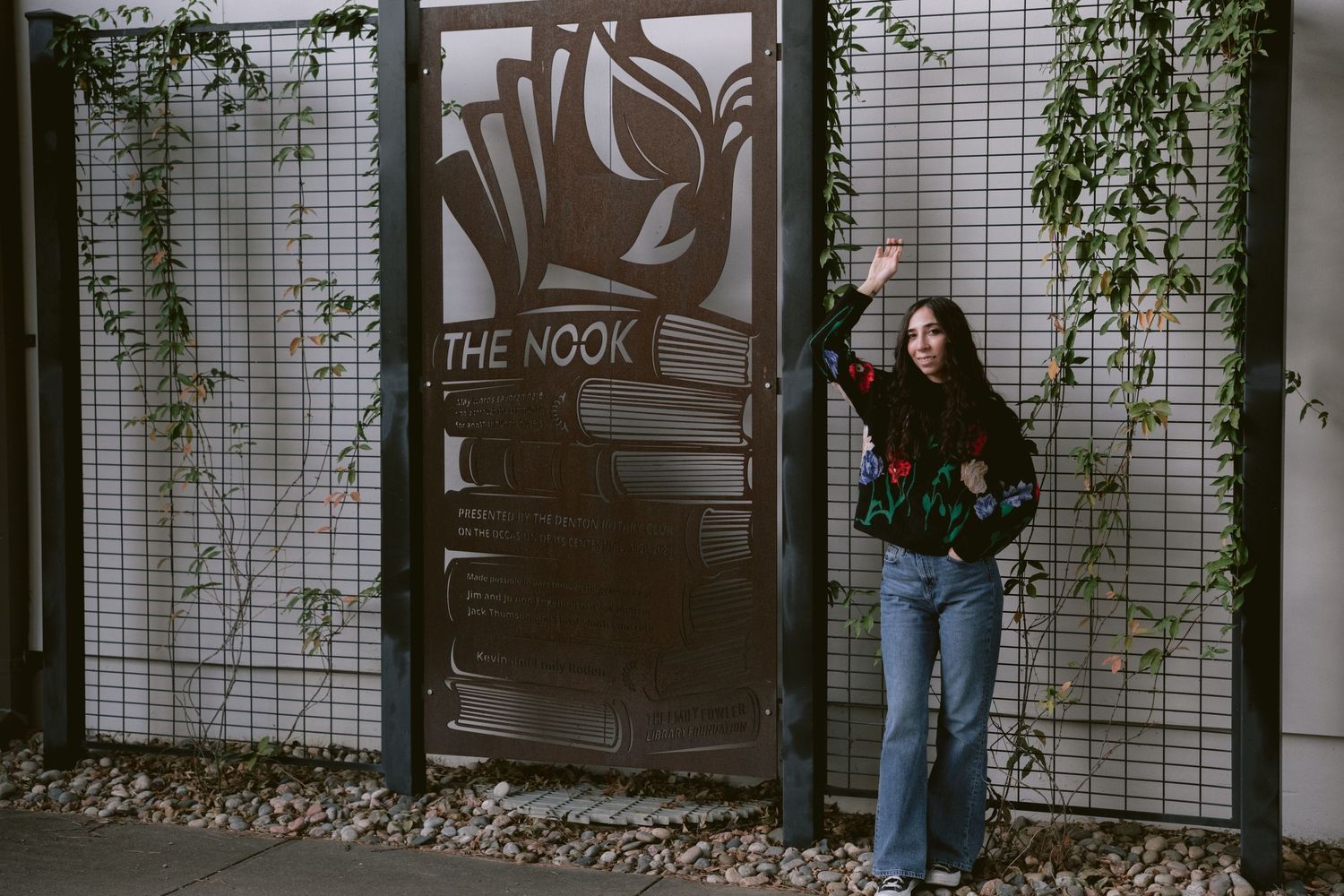 A librarian posing in front of Emily Fowler Library in Denton, TX.