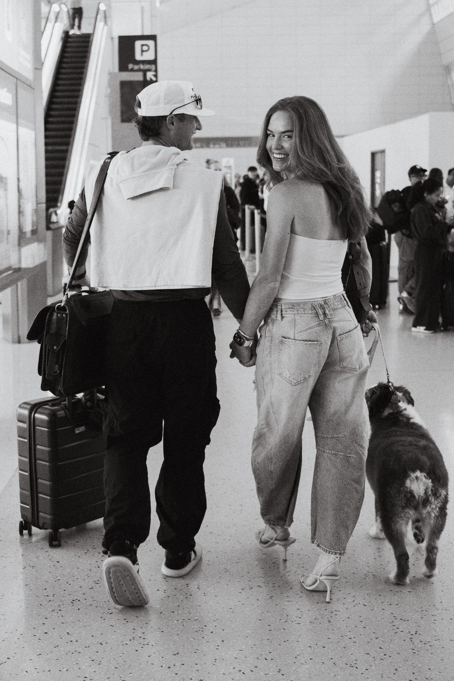 A couple and their dog walking through the airport