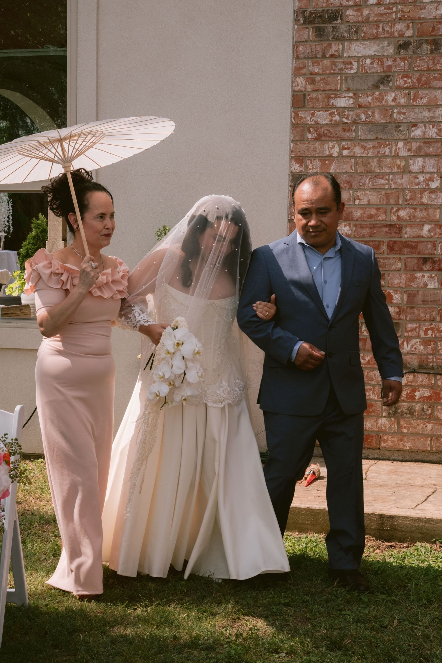 A bride walking down the aisle at their backyard wedding in Denton, TX