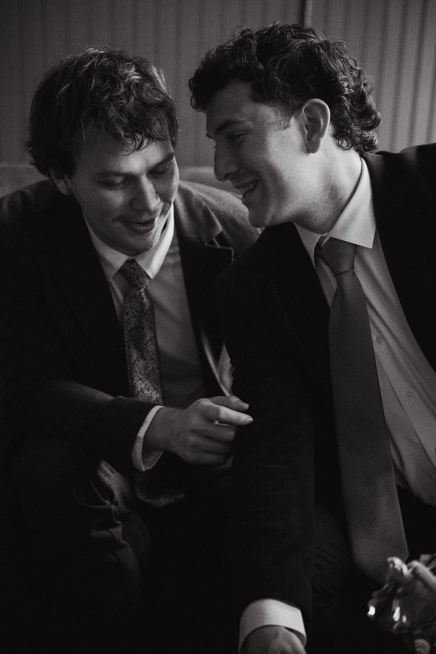 Two grooms laughing over tea