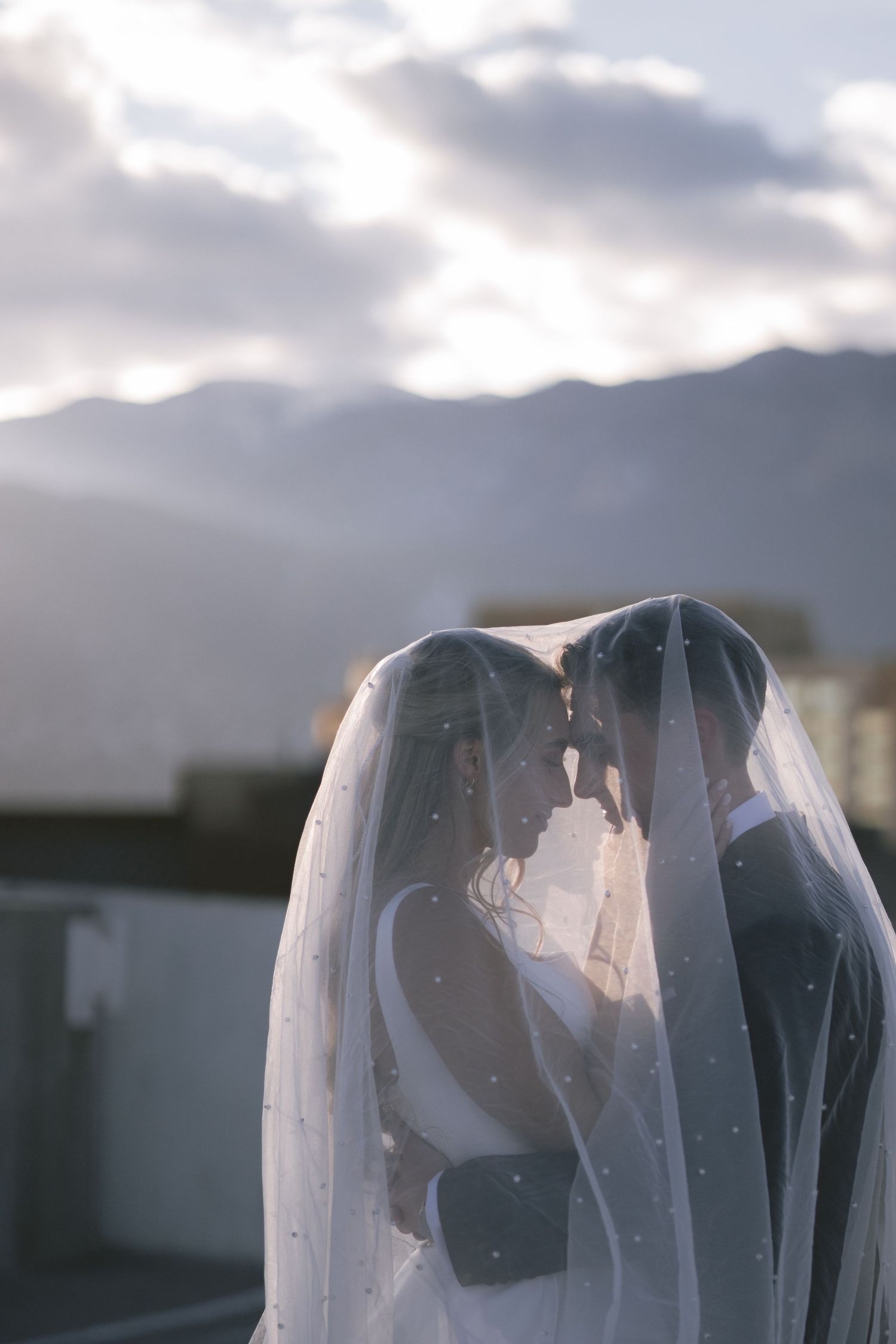 A couple on a rooftop under a veil in Colorado Springs, CO