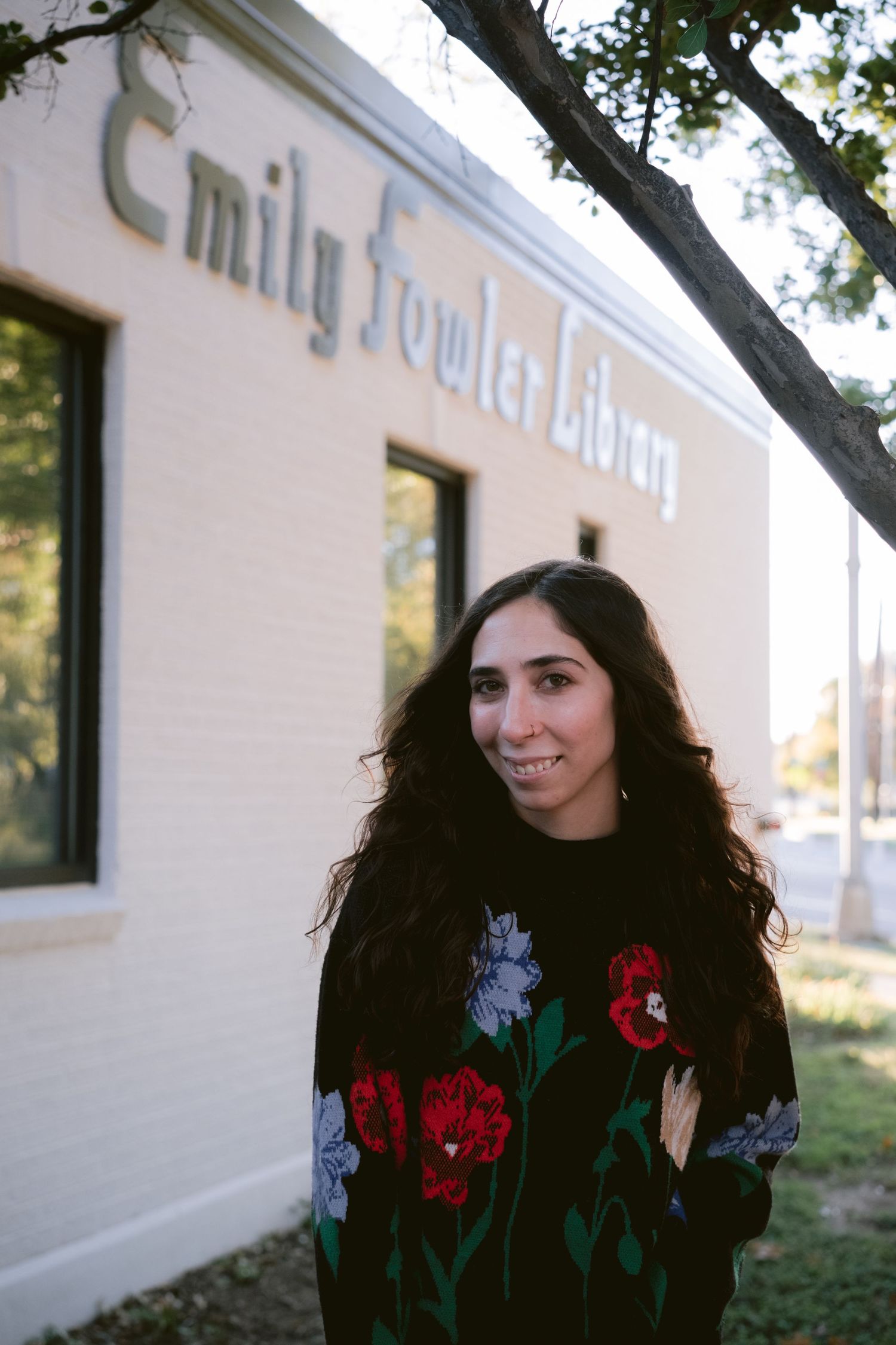 A librarian posing in front of Emily Fowler Library in Denton, TX.