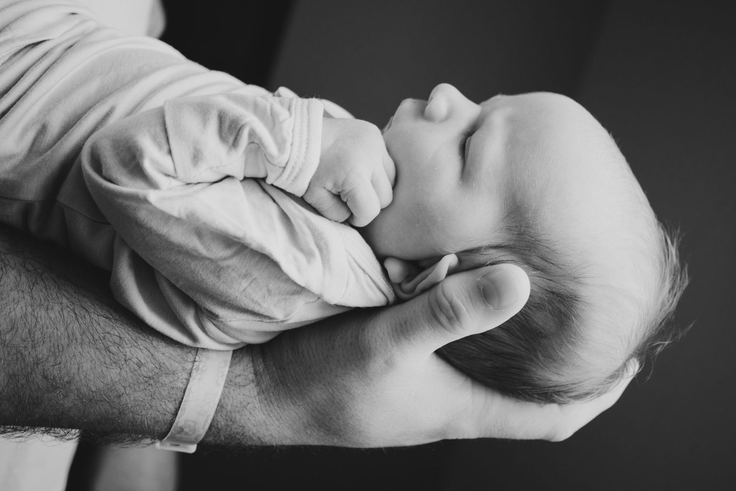 A dad gently holding his newborn son in Fort Worth, TX
