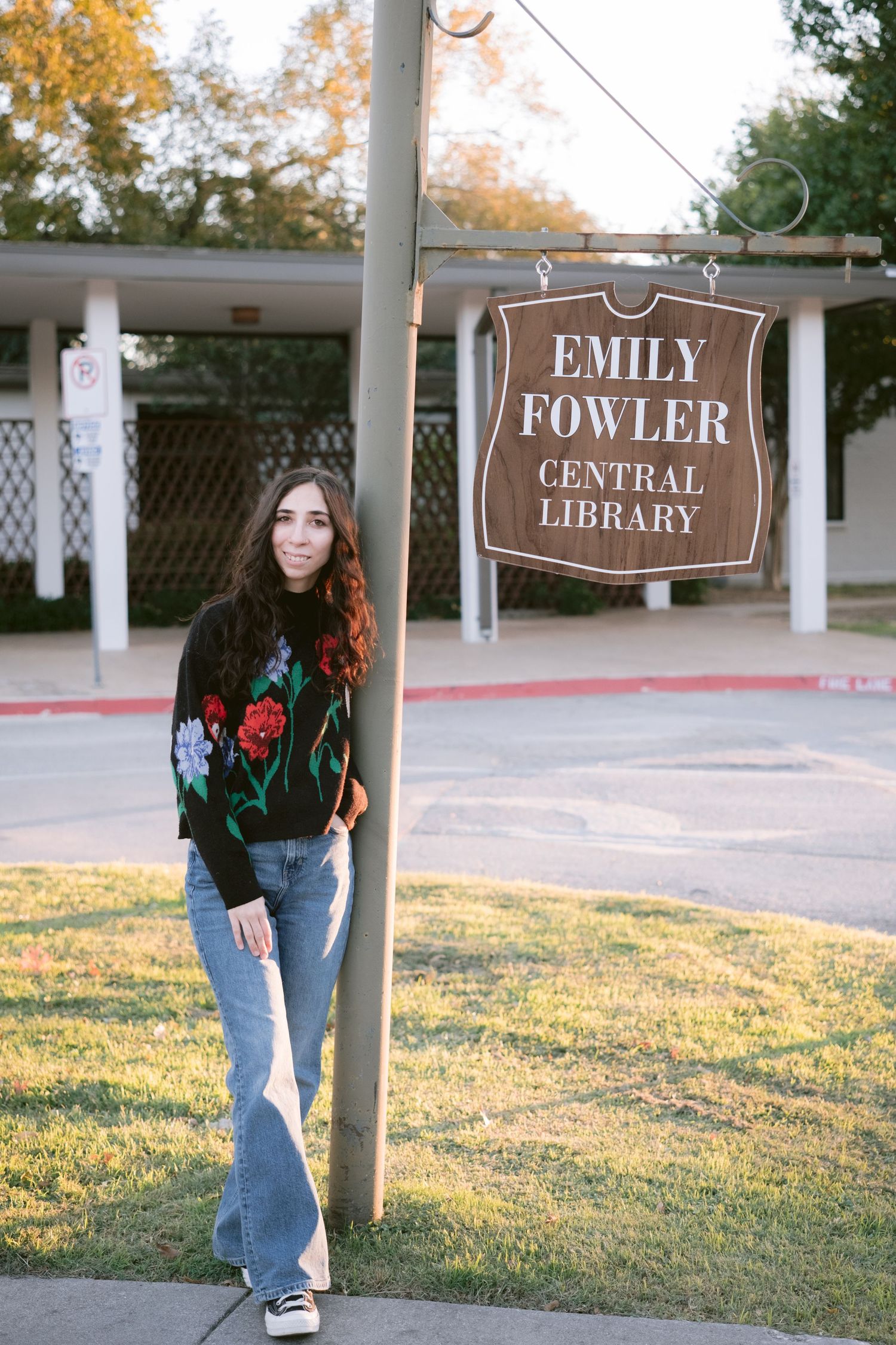A librarian posing in front of Emily Fowler Library in Denton, TX.