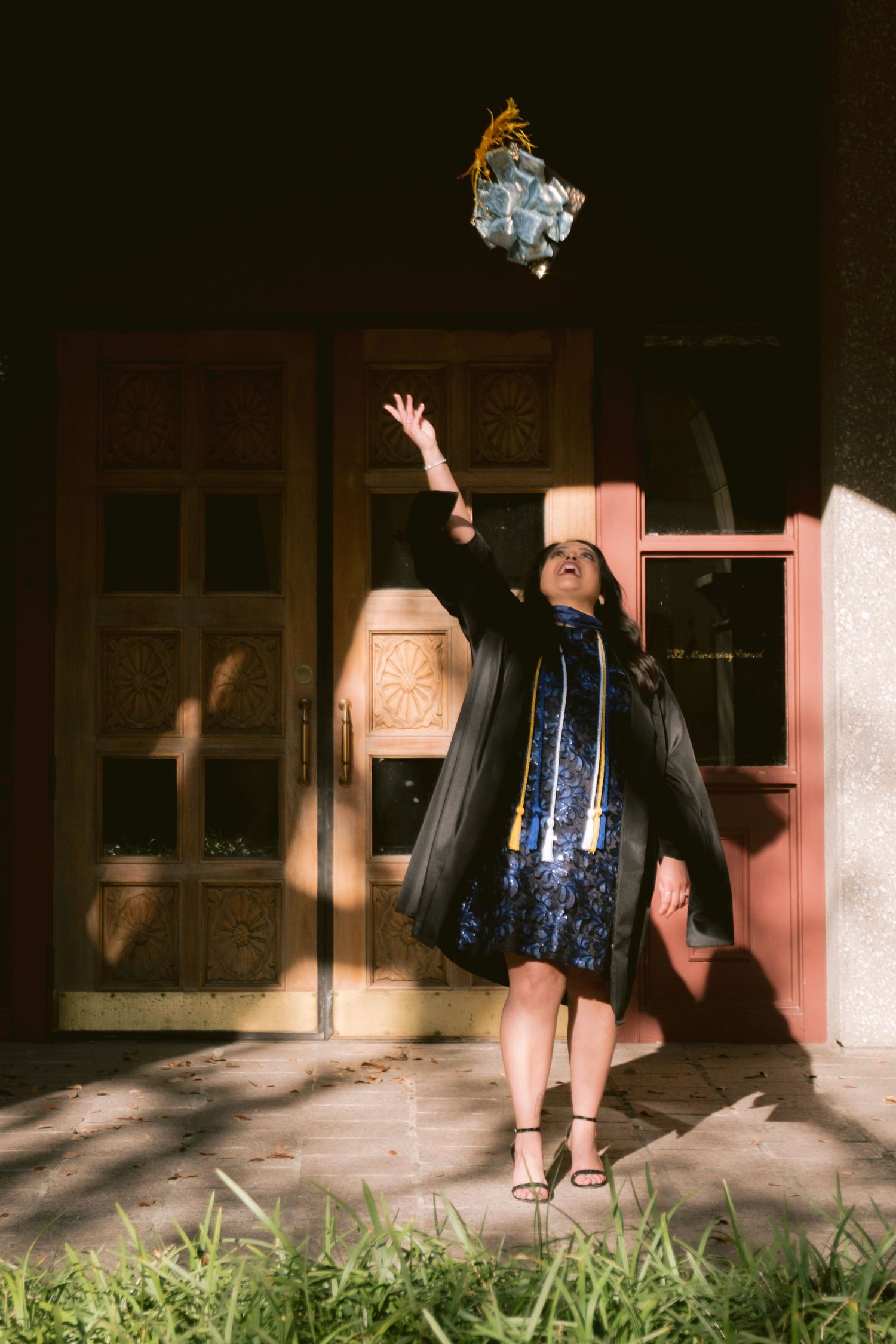 A graduate tosses her cap at the Mandalay Canal Walk in Las Colinas, TX