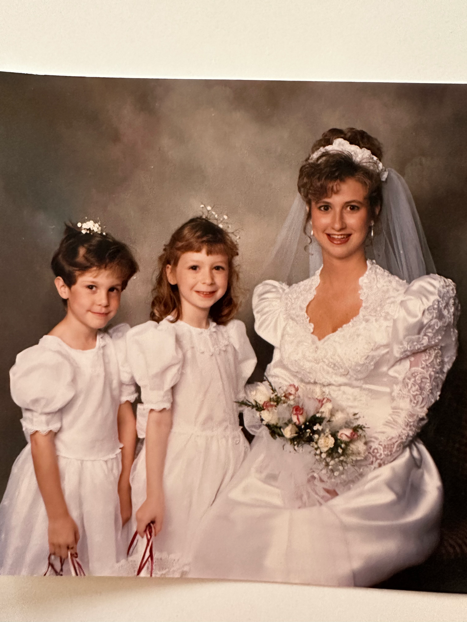 Four similar photos show wedding party members in white lace dresses posing professionally in identical poses.