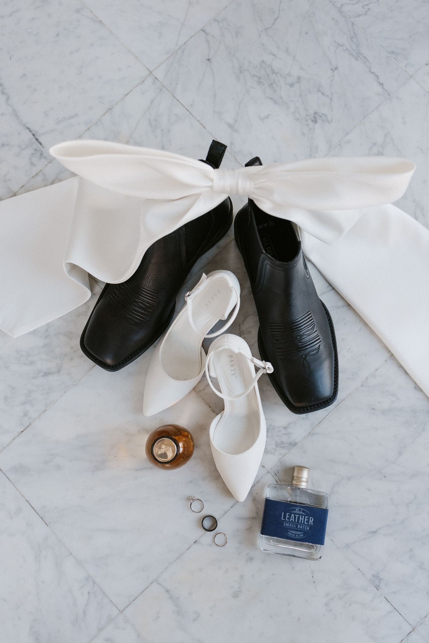 Leo Ballroom marble floor, wedding details with bride's shoes, groom's shoes, wedding rings and wedding scents.