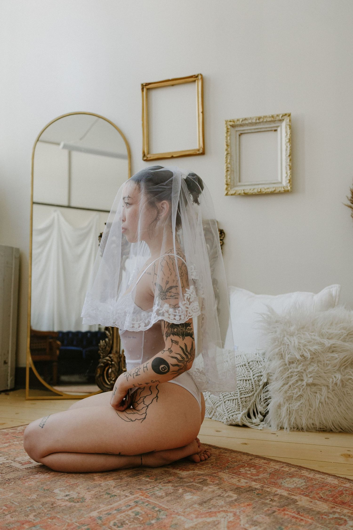 Woman posing her veil in white lingerie in a private studio in Plattsmouth Nebraska for a bridal boudoir session