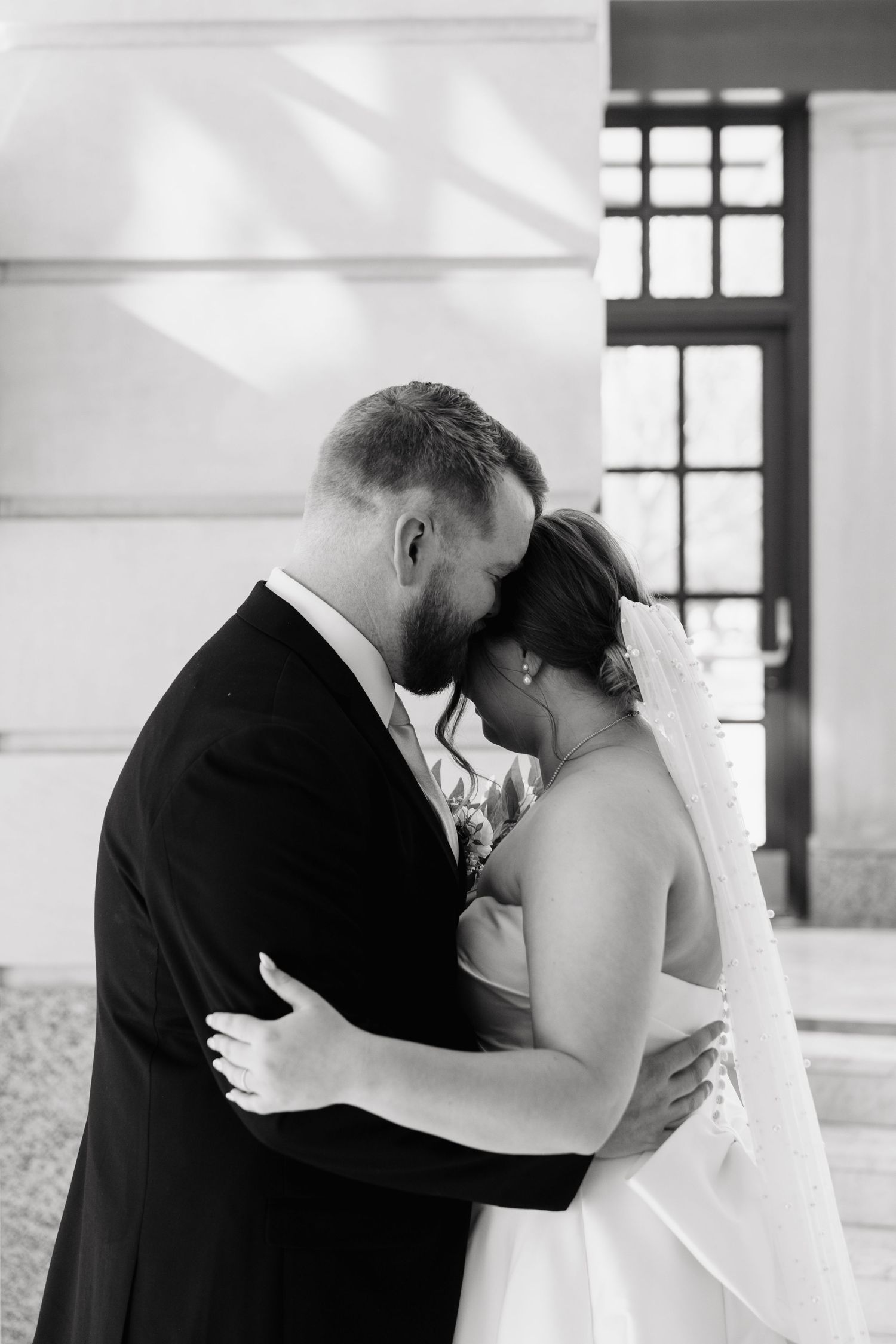 Bride and Groom having a private moment in the entry way of the Leo Ball room