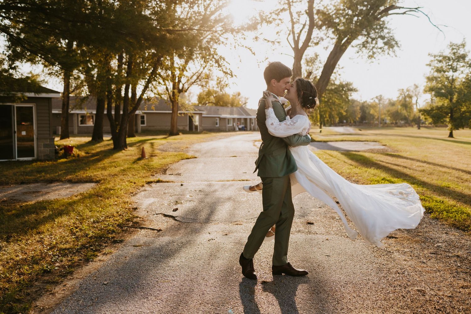 Bride and groom walking through colorful fall trees during their Falconwood Park wedding in Bellevue, NE.