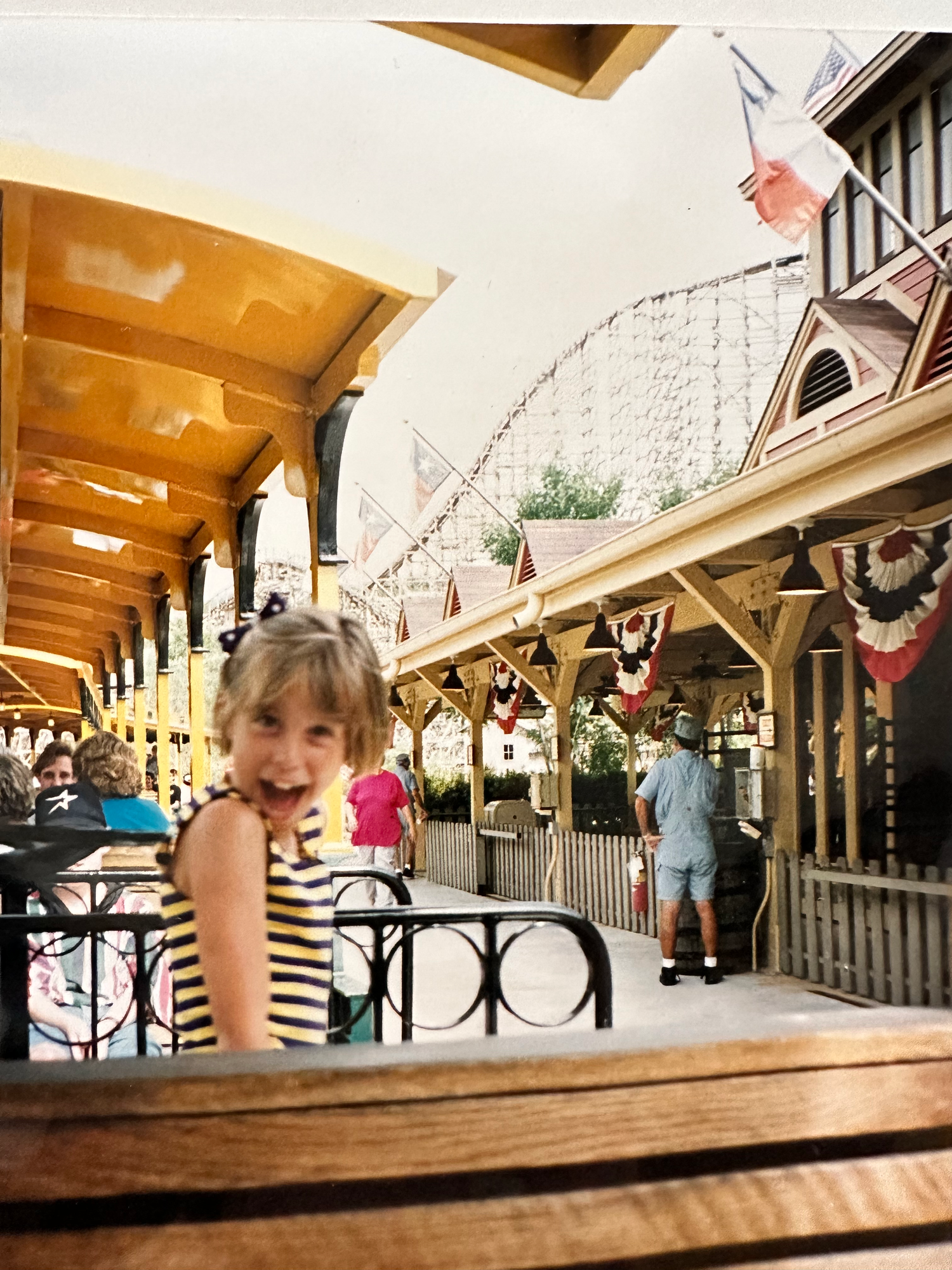 A unique moving panoramic view of a wooden carousel ride with passengers in motion creating a blurred effect.