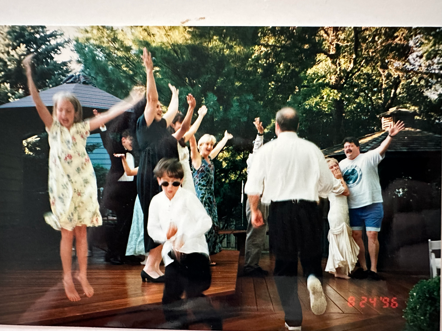Wedding guests dance and celebrate outdoors in a candid photo series showing joyful movement and festive energy.