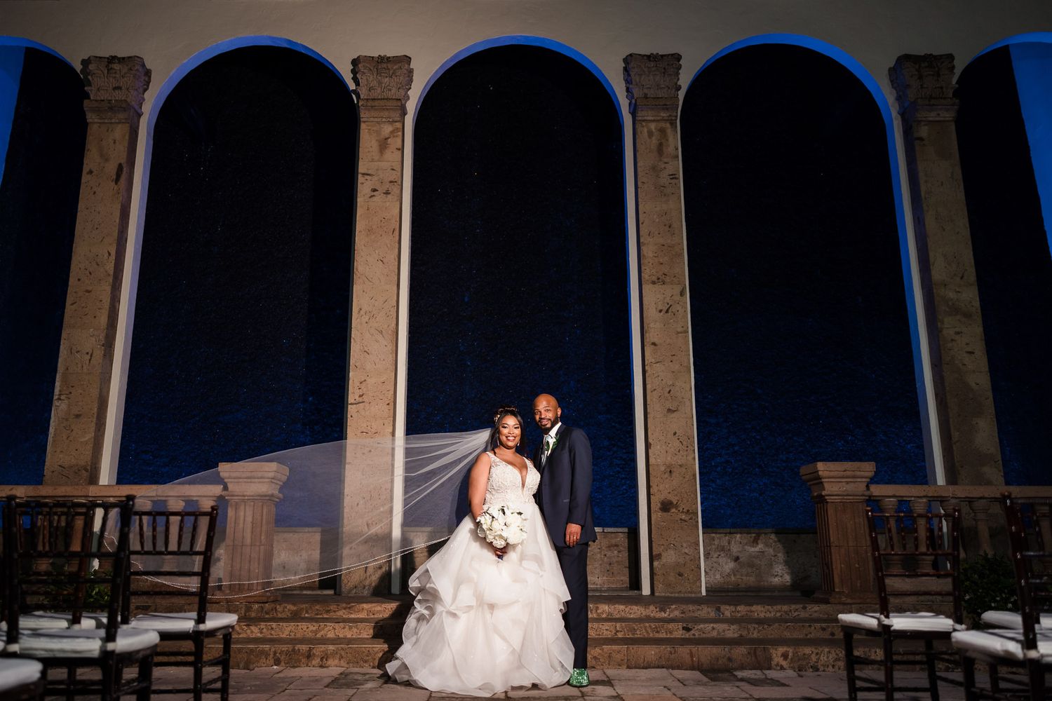 Couple kissing at the blue-lit Waterwall, Bell Tower on 34th at night