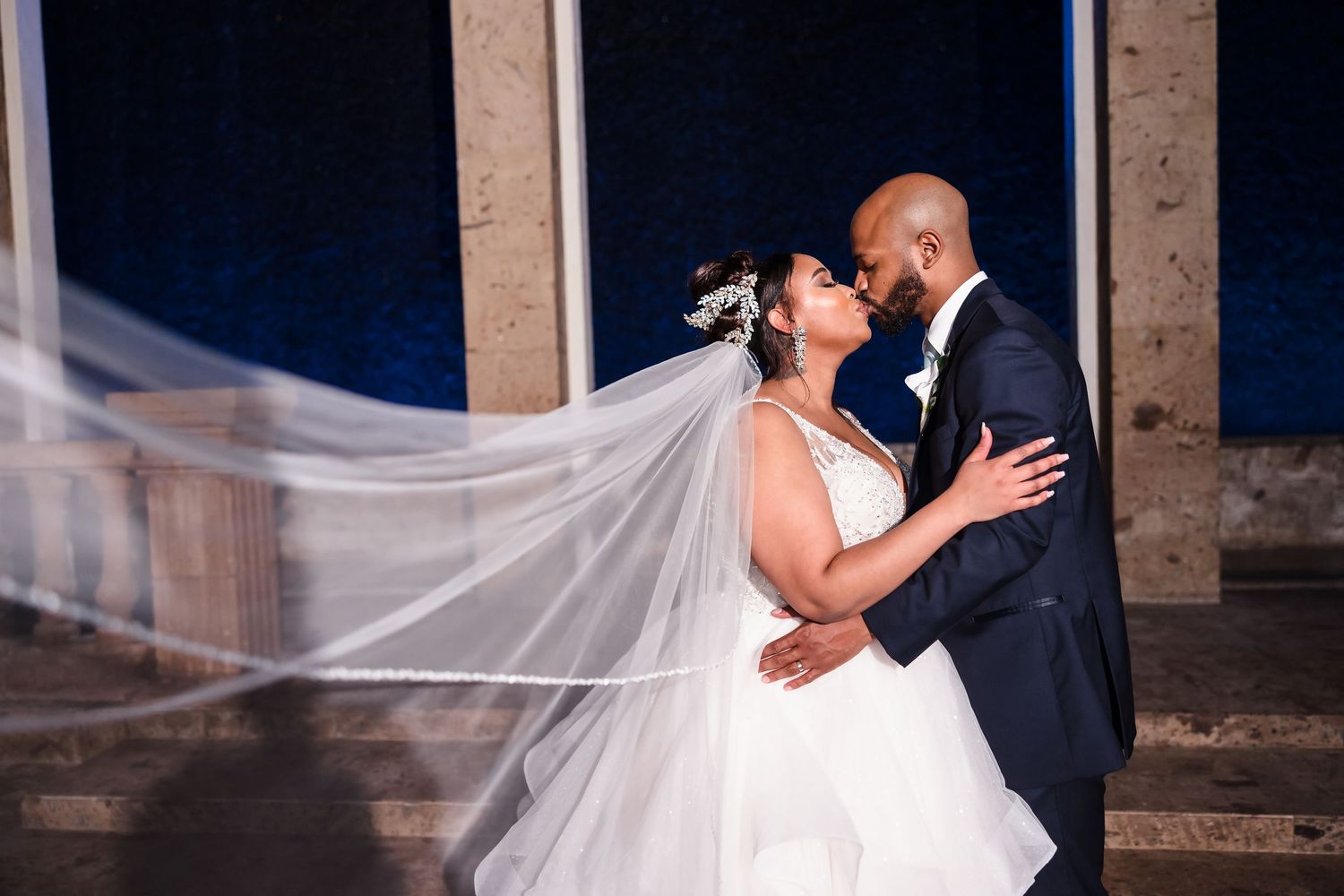 Bride and groom kissing under chandelier